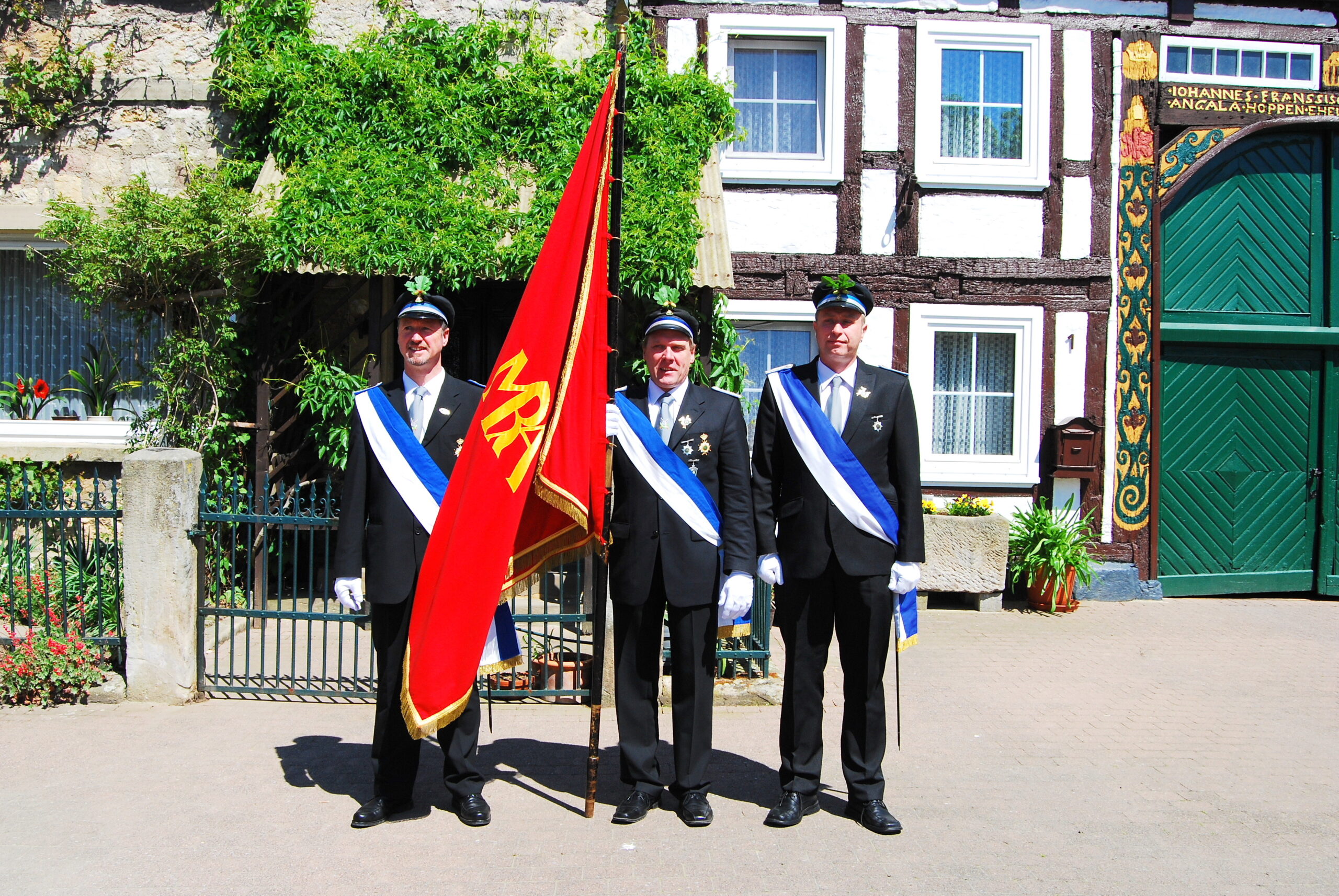 Drei Mitglieder des Nörder Schützenvereins präsentieren die erste Fahne.