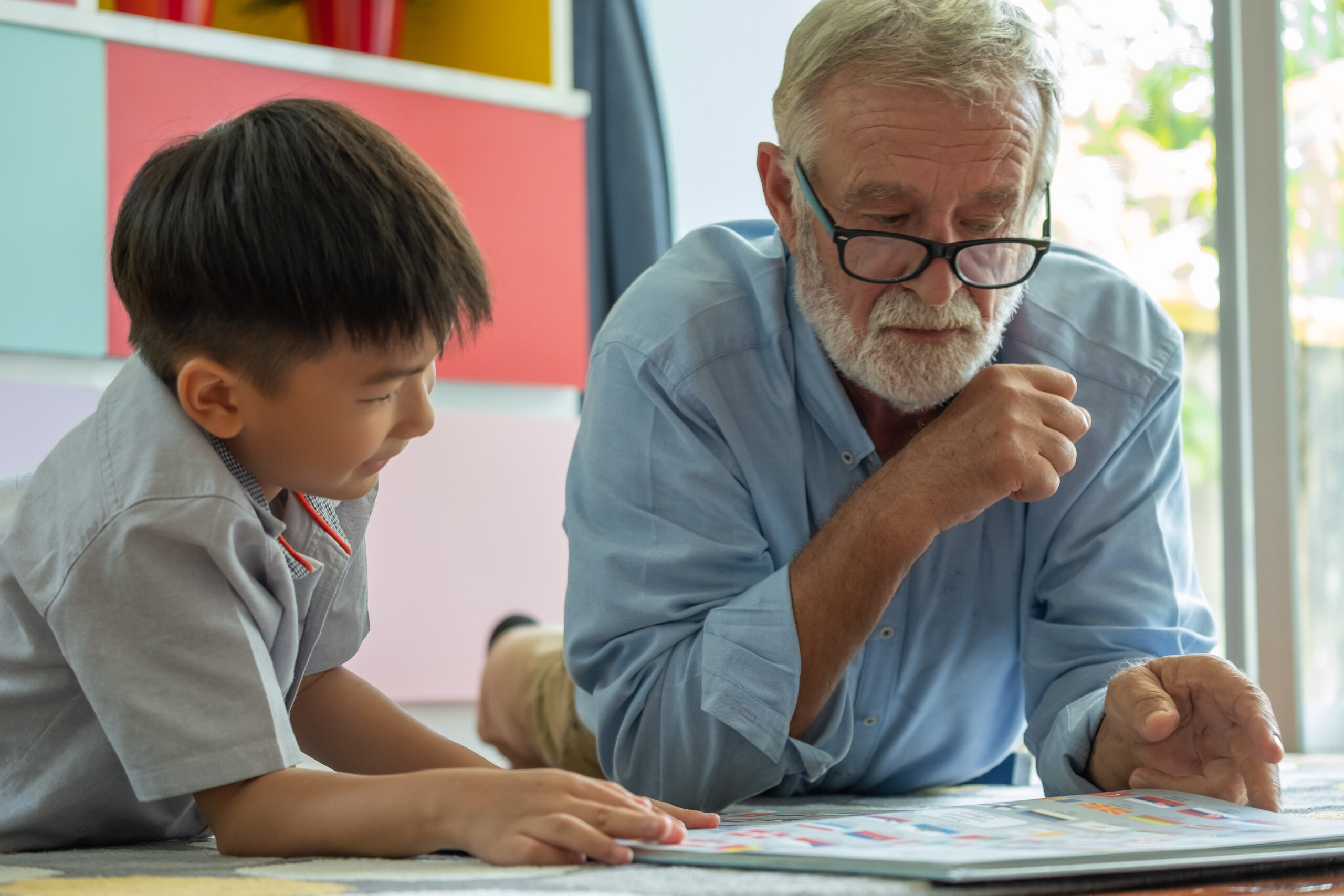 Ein älterer Mann hilft einem Kind bei den Hausaufgaben