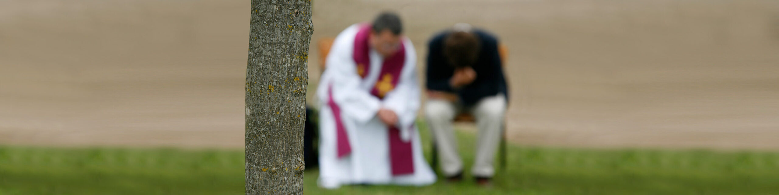 Ein Priester nimmt einem Mann die Beichte ab