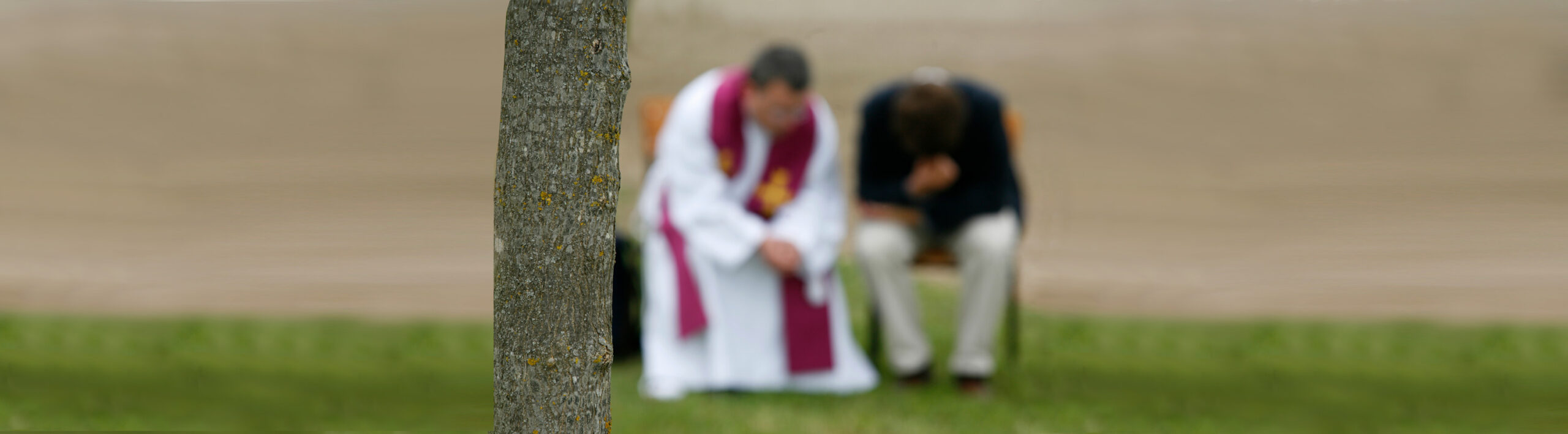 Ein Priester nimmt einem Mann die Beichte ab