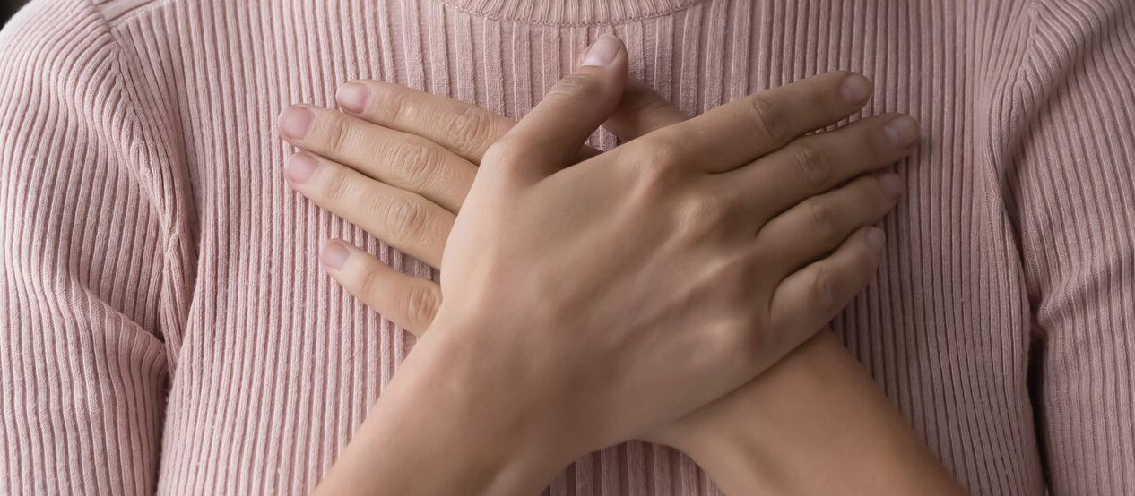 Frau hält Hände aufs Herz