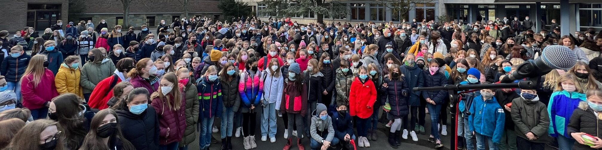 Viele Schülerinnen und Schüler auf einem Schulhof