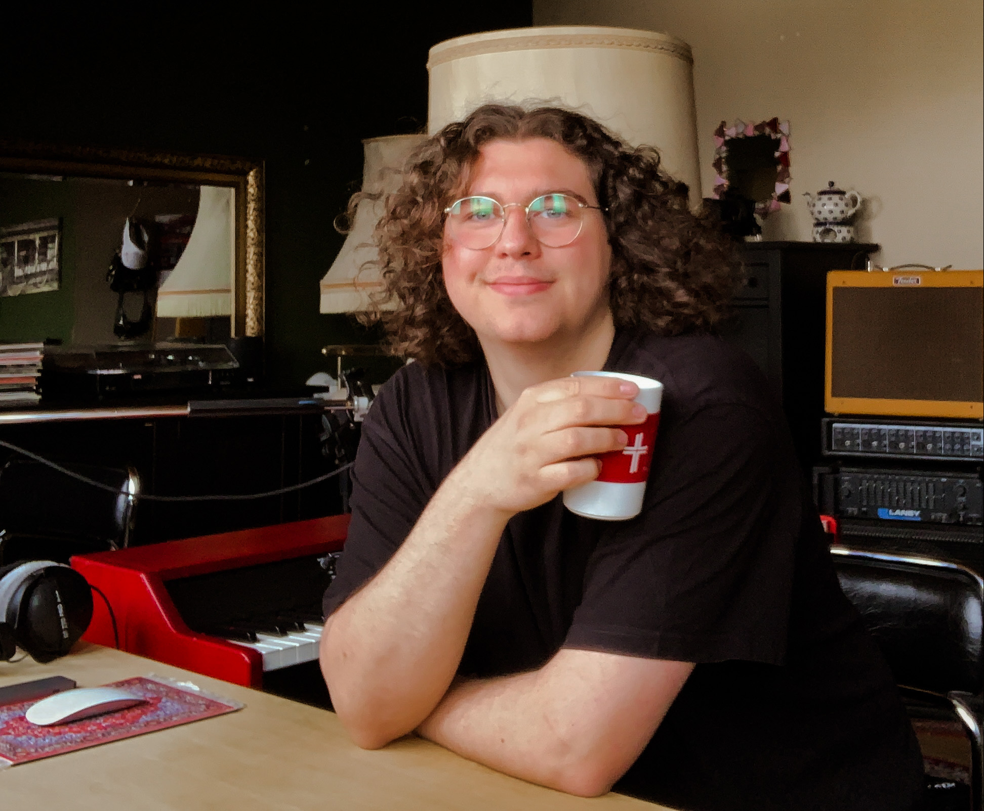 Musikstudent Caspar Beule in seinem Studio mit einem Kaffeebecher in der Hand