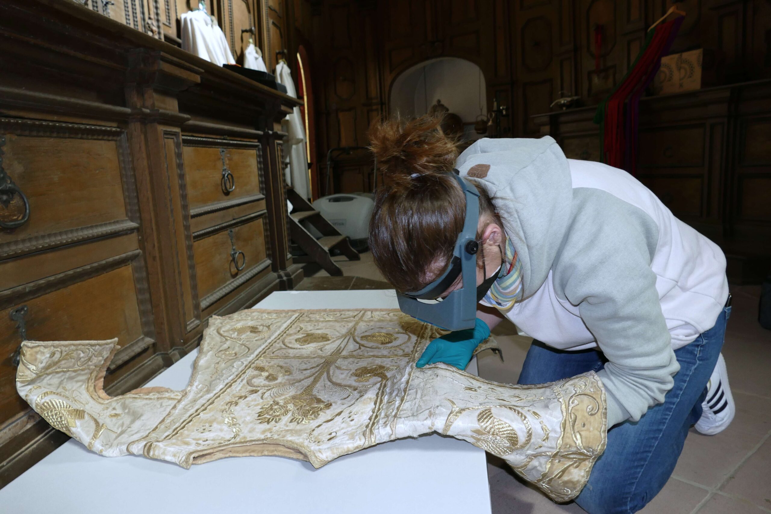 Carmen Markert begutachtet in der Sakristei der ehemaligen Abteikirche eines der kostbaren liturgischen Gewänder, die sie in ihrer Werkstatt in Hannover für die Dauerausstellung restaurieren wird.
