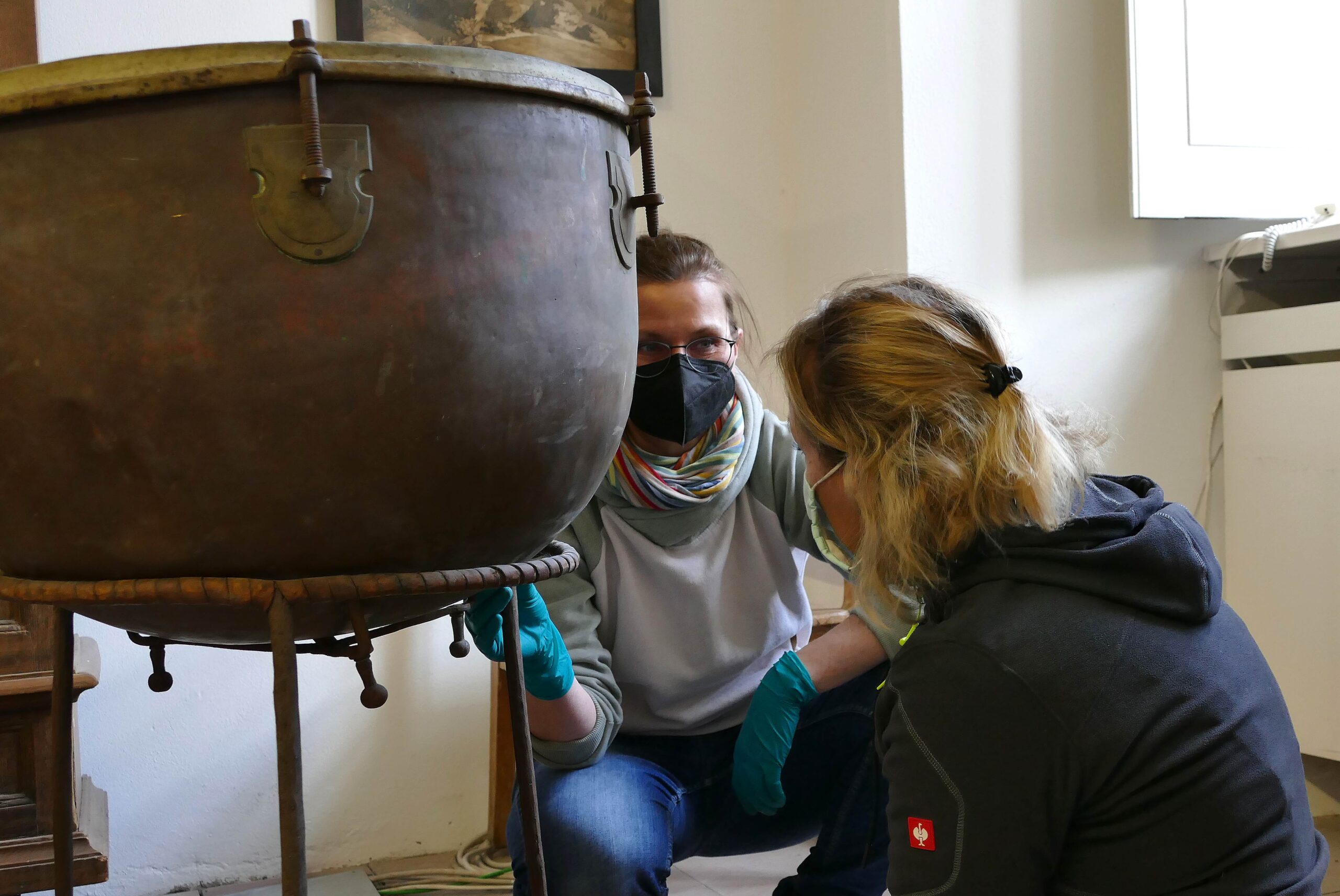 Interdisziplinär arbeiten die Textilrestauratorin Carmen Markert (links) und die Metallrestauratorin Dorothee Brück bei den Kesselpauken zusammen. Das Leder des Rings, auf dem der Kessel ruht, fällt in das Ressort von Carmen Markert. Das lockere Bein eines der beiden Gestelle ist dann schon wieder Dorothee Brücks Part.