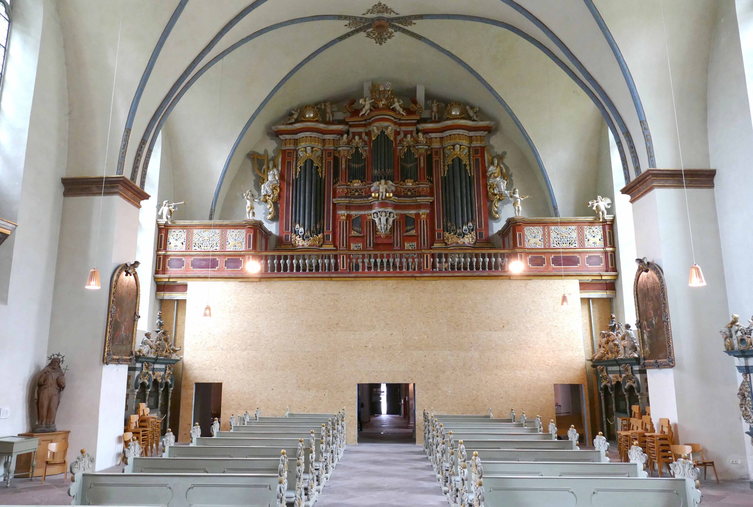 Die Staubschutzwand ist ein auf ihre Weise besonderer Anblick. Die Engelatlanten, die die Orgelbühne tragen, sind hinter ihr verschwunden.