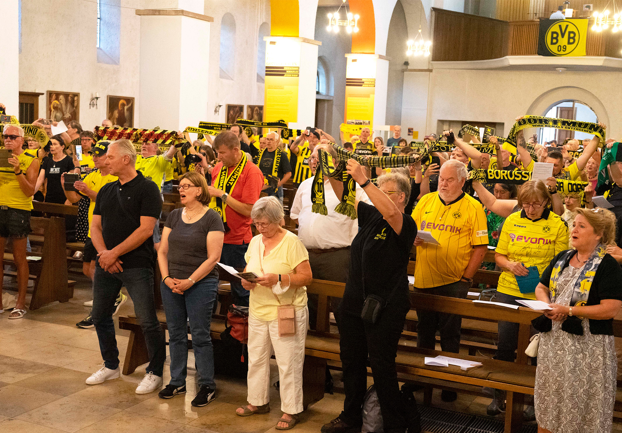 Fahnen, Hymnen und Schals prägen die besondere Atmosphäre der BVB-Gottesdienste in der katholischen Dreifaltigkeitskirche in Dortmund, so auch am Donnerstag beim Gottesdienst zur Saisoneröffnung 2022 / 2023. Foto: Michael Bodin / Erzbistum Paderborn