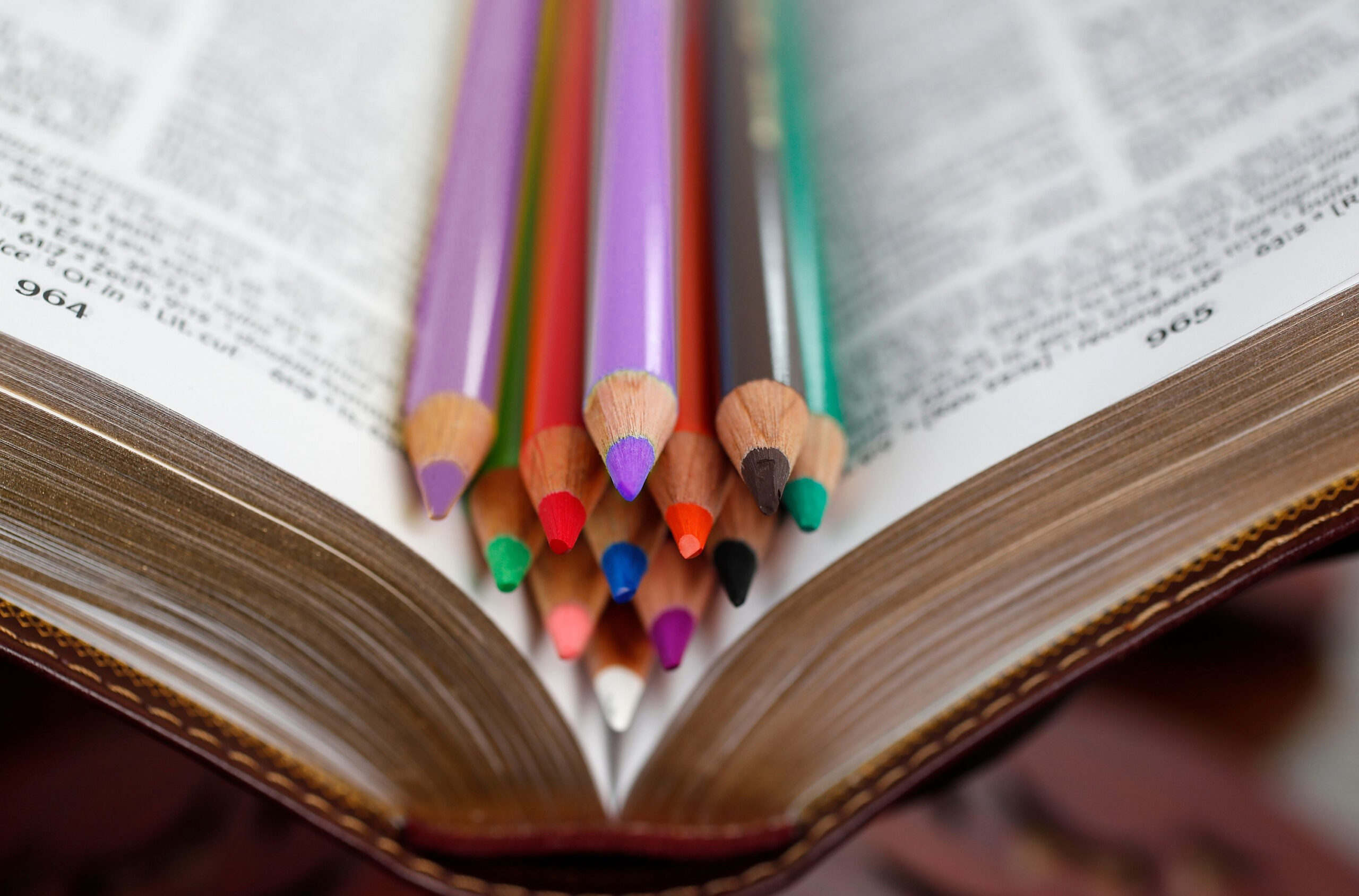 Bibel mit Buntstiften in den Farben des Kirchenjahres