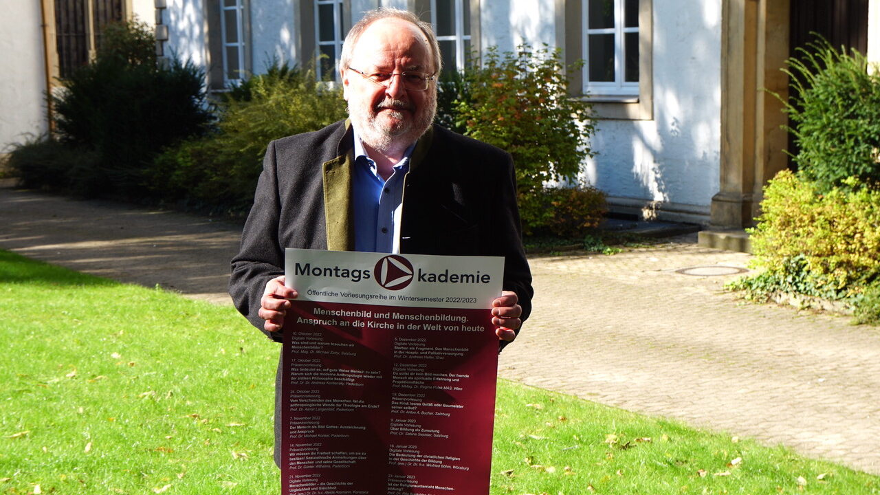 Prof. Dr. Herbert Haslinger mit Plakat zur Montagsakademie im WiSe 2022/23