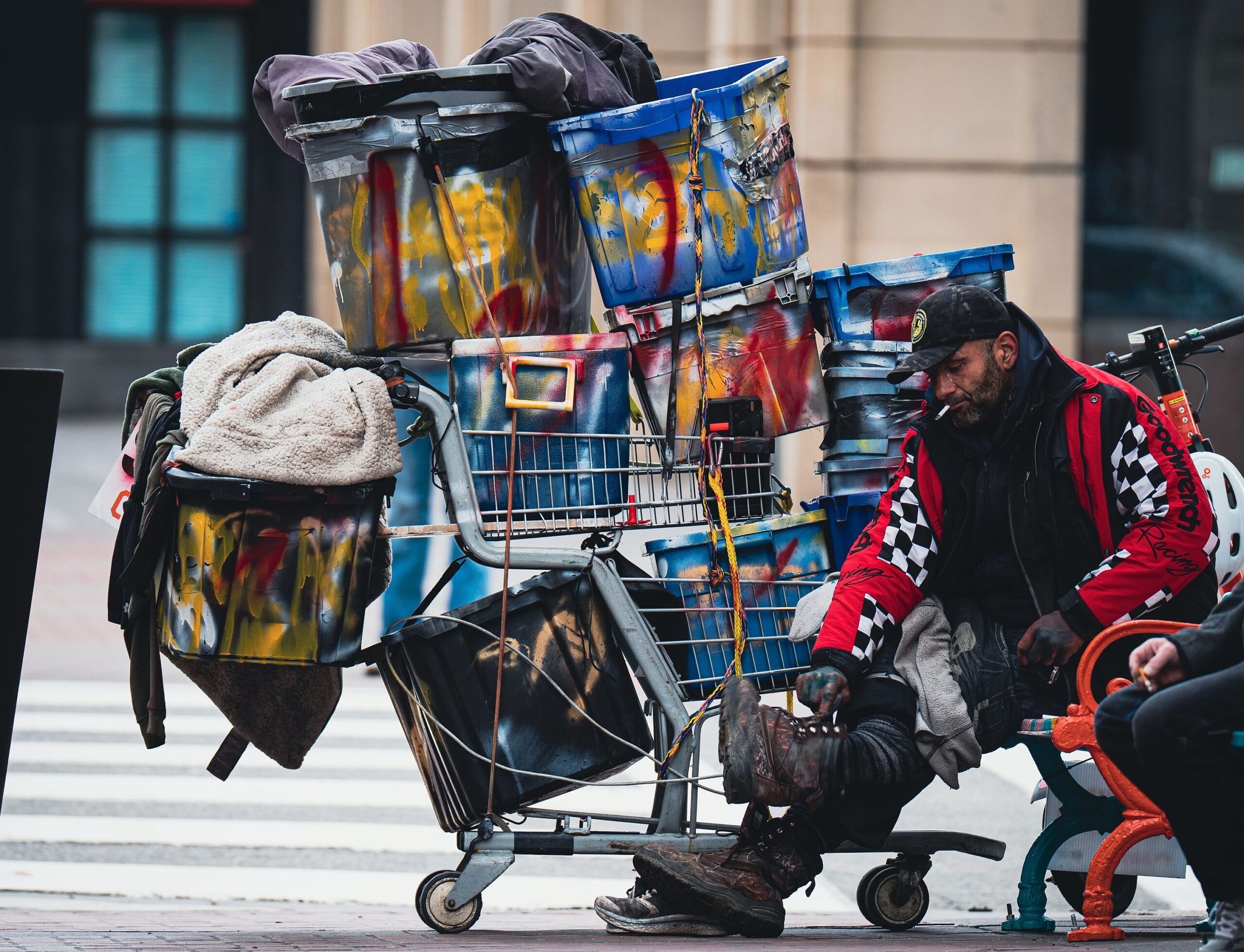 Obdachlos mit Einkaufswagen voll mit seinem Hab und Gut