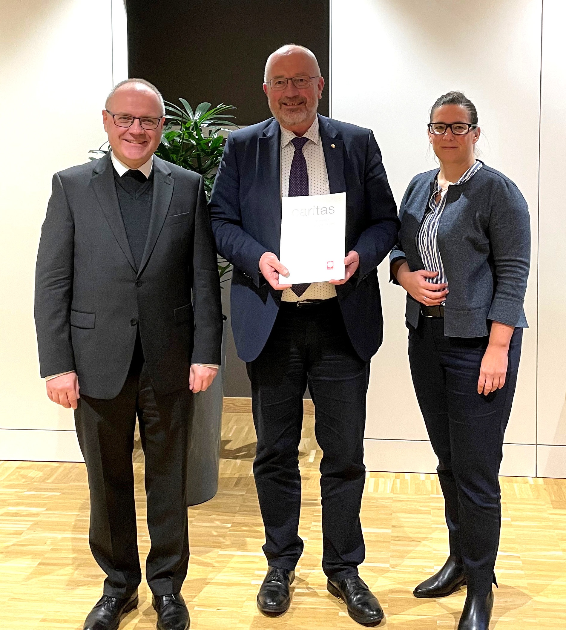 Josef Lüttig wurde für seine Verdienste mit dem Caritas-Ehrenzeichen in Gold ausgezeichnet. Überreicht wurde ihm die Auszeichnung von Domkapitular Dr. Thomas Witt (links), Vorsitzender des Diözesan-Caritasrates. Mit dabei: Diözesan-Caritasdirektorin Esther van Bebber.