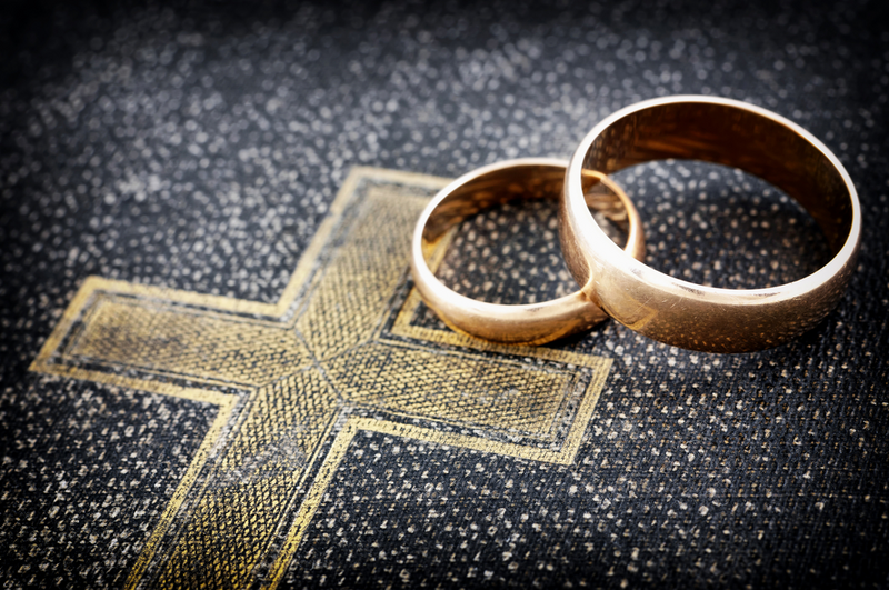 Nahaufnahme einer Bibel mit goldenen Eheringen darauf