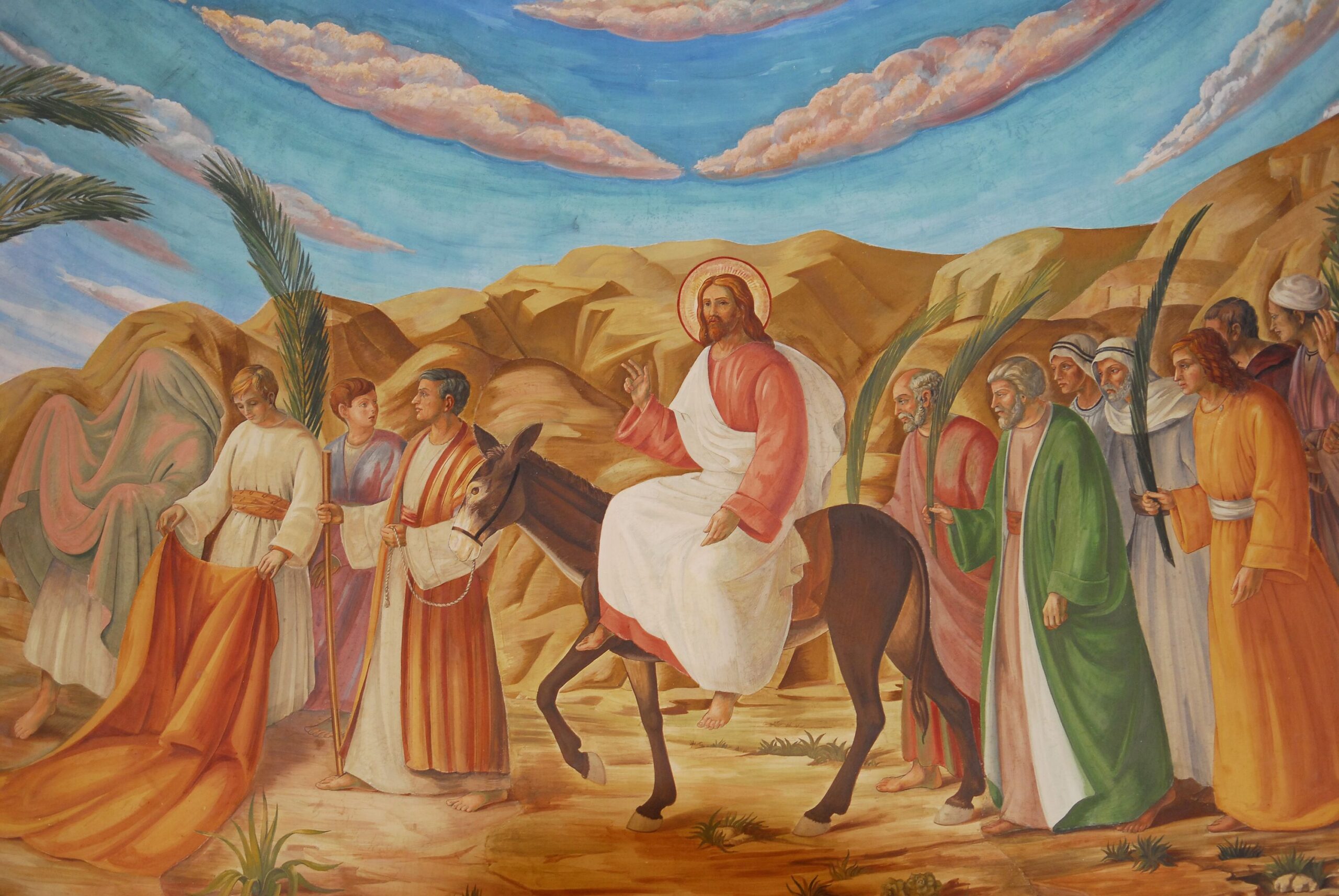 Jesus reitet auf einem Esel nach Jerusalem, die Menschen legen Palmzweige und ihre Mäntel auf den Weg.