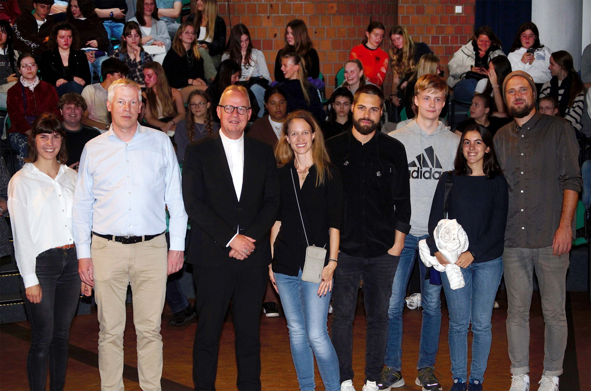 Auftaktveranstaltung zu den Firmungen im Dekanat Dortmund (v.l.): Christina Strunck (Moderation), Tobias Ebert (stellvertretender Schulleiter), Weihbischof Josef Holtkotte, Svenja Zahn (Dekanatsreferentin f. Jugend und Familie), Jonnes (Sänger/ Künstler), ein Firmbewerber und eine Firmbewerberin und Marco Michalzik (Poetry Künstler). Foto: privat