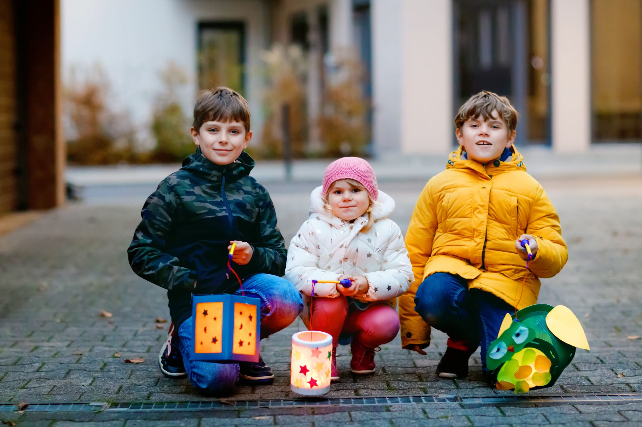 3 Kinder mit ihren Laternen mit Kerzen für den St.-Martins-Umzug.