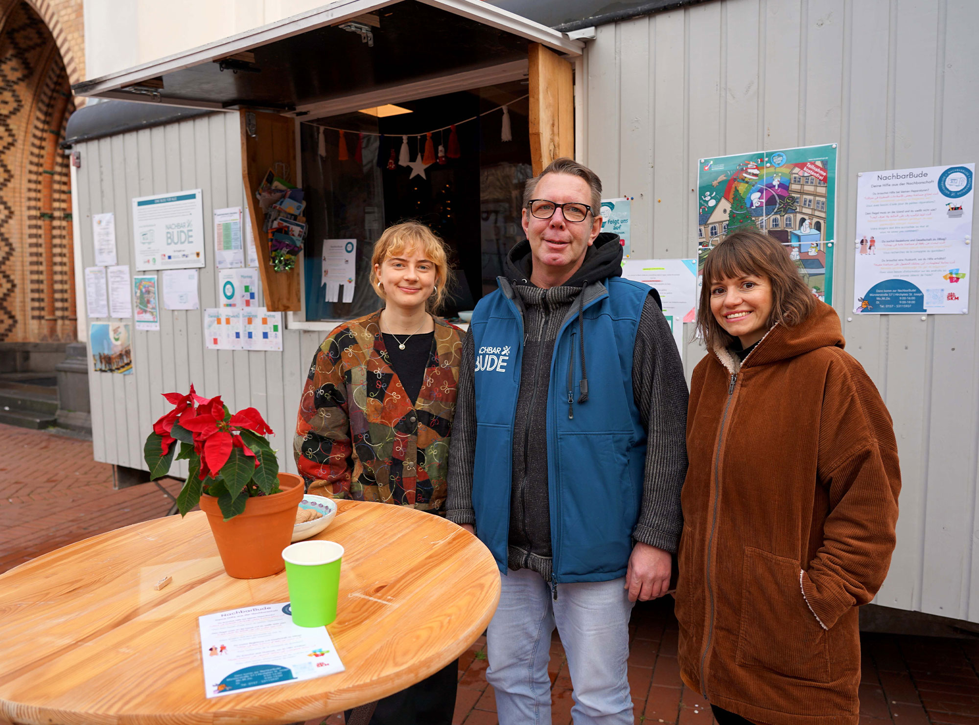 Die „NachbarBude“ des katholischen Sozialdienstes SKM Dortmund e.V. bietet auf dem Kirchplatz von St. Josef verschiedene Hilfen für Menschen aus der Nachbarschaft sowie Informationen. Im Bild v.l.: Paula Giesen (SKM), Jürgen Grewe (SKM) und Silvia Koslowski (Projektkoordinatorin SKM). Foto: Michael Bodin / Erzbistum Paderborn