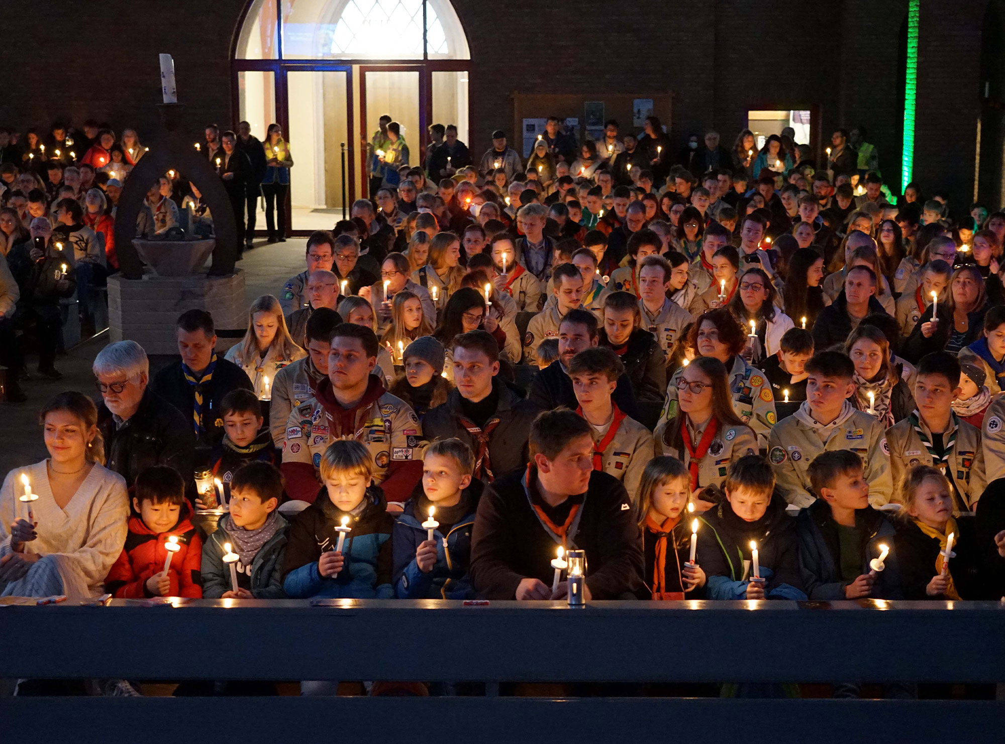 Am dritten Adventssonntag gaben Pfadfinderinnen und Pfadfinder in der St. Joseph-Kirche in Dortmund-Nord das Friedenslicht weiter und nahmen es mit in ihre Gemeinden. Foto: Michael Bodin / Erzbistum Paderborn