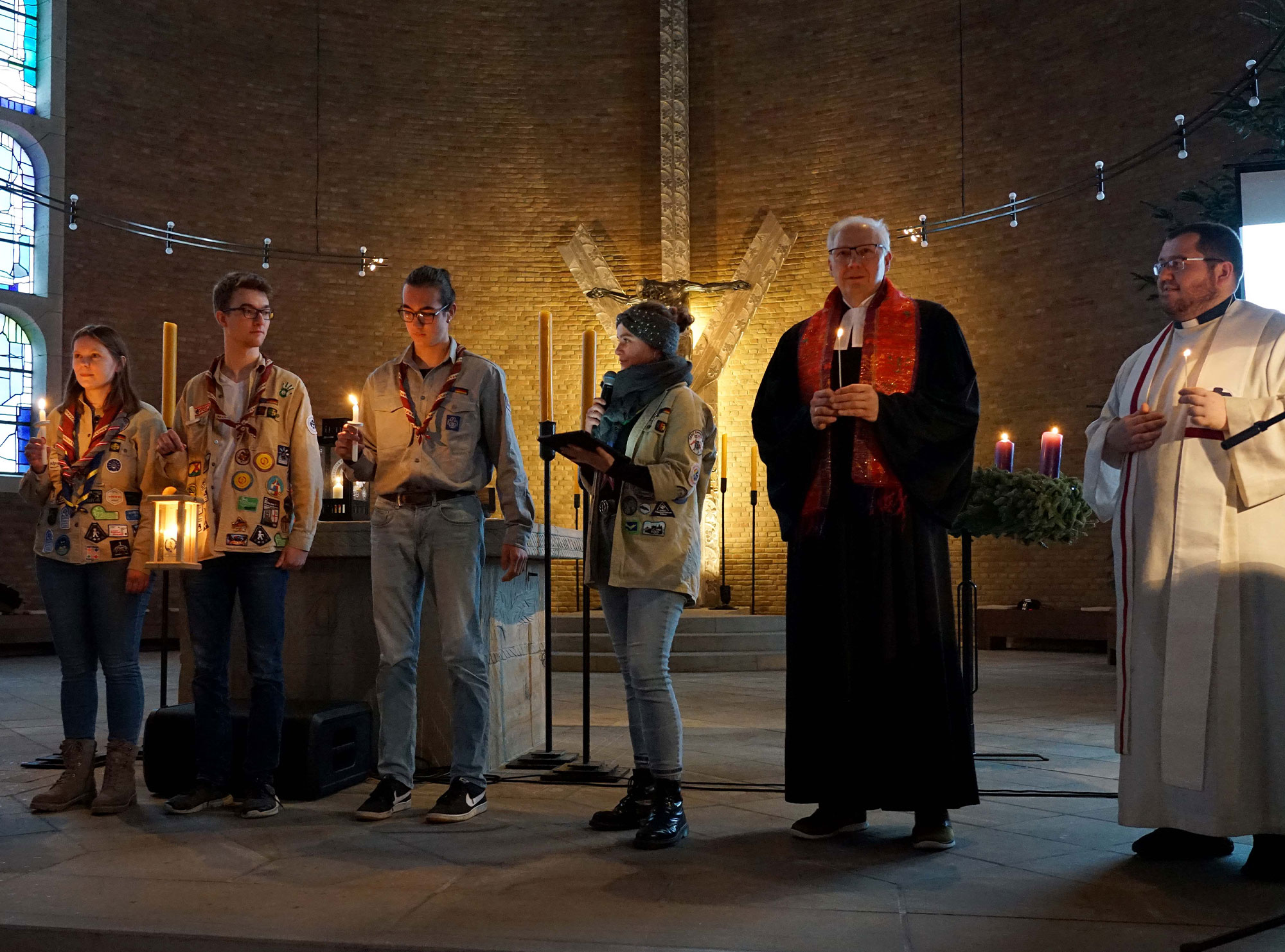 Zusammen mit einer Abordnung der Pfadfinderinnen und Pfadfinder, die das Friedenslicht aus Linz in Österreich mitbrachten, sowie weiteren Pfadfinderinnen und Pfadfindern, gestalteten der evangelische Landesjugendpfarrer Branko-Christian Uhlstein (2.v.r.) und Thorsten Hasse, Diözesankurat der Deutschen Pfadfinderschaft St. Georg (DPSG) (1.v.r.) in Dortmund den Aussendungsgottesdienst für das Friedenslicht aus Bethlehem. Foto: Michael Bodin / Erzbistum Paderborn