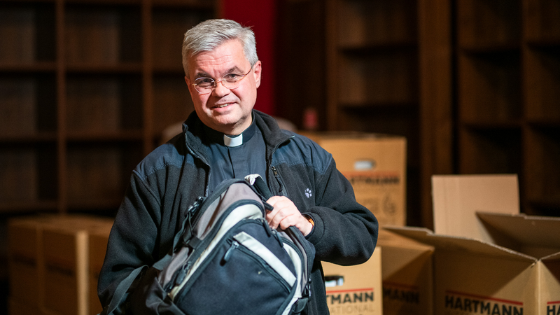 Erzbischof Bentz hält einen Rucksack.