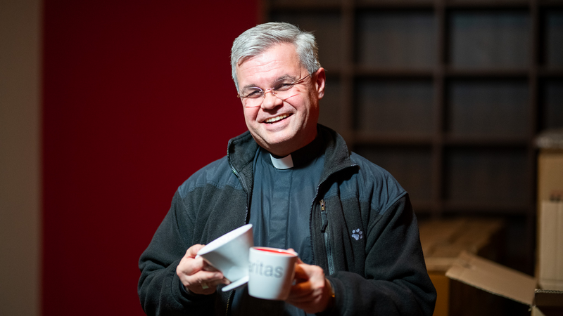 Erzbischof Udo Markus Bentz hält einen Kaffeefilter und eine Kaffeetasse
