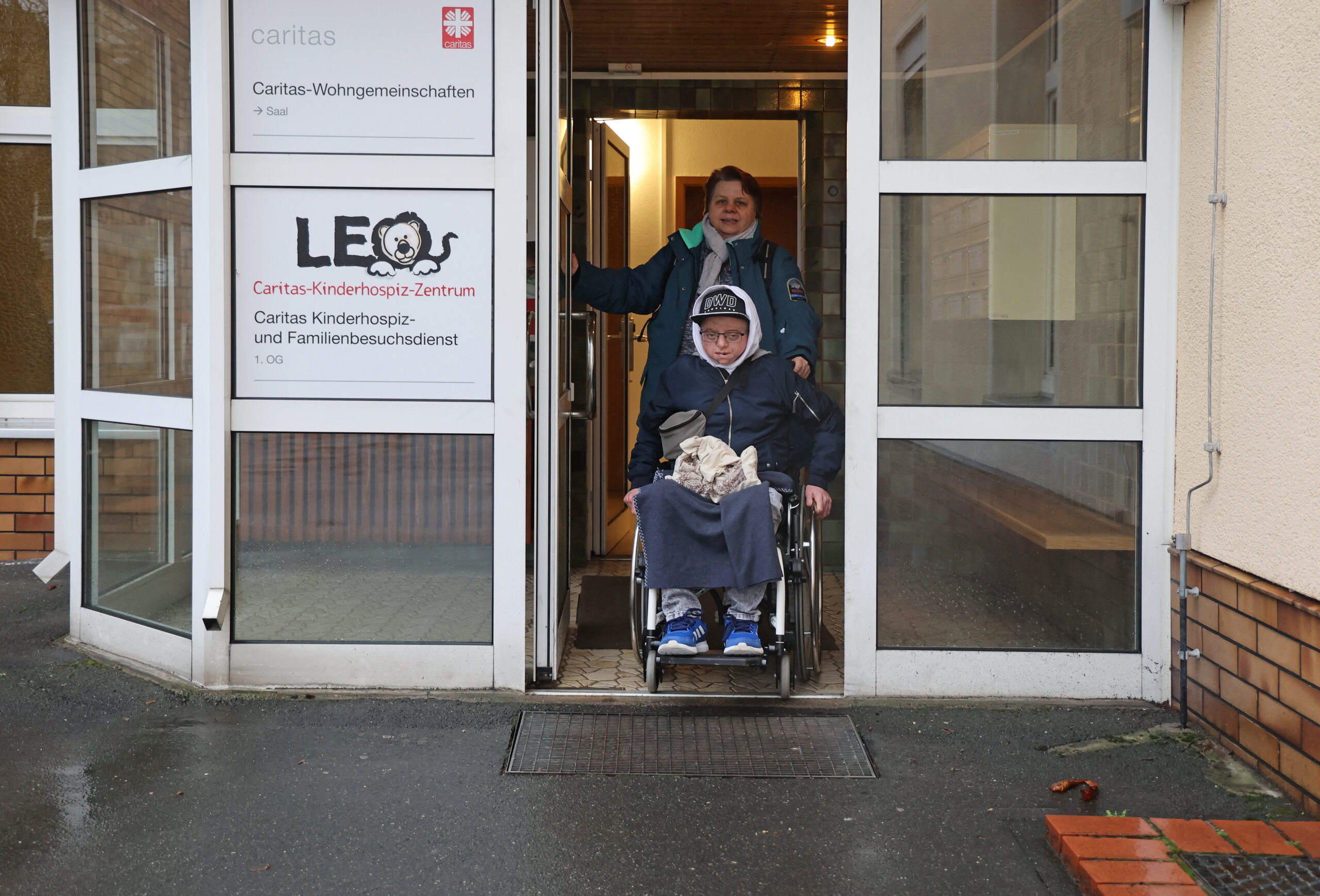 Luca Campos und seine Mutter Heike am Eingang des Kinderhospiz-Zentrums LEO