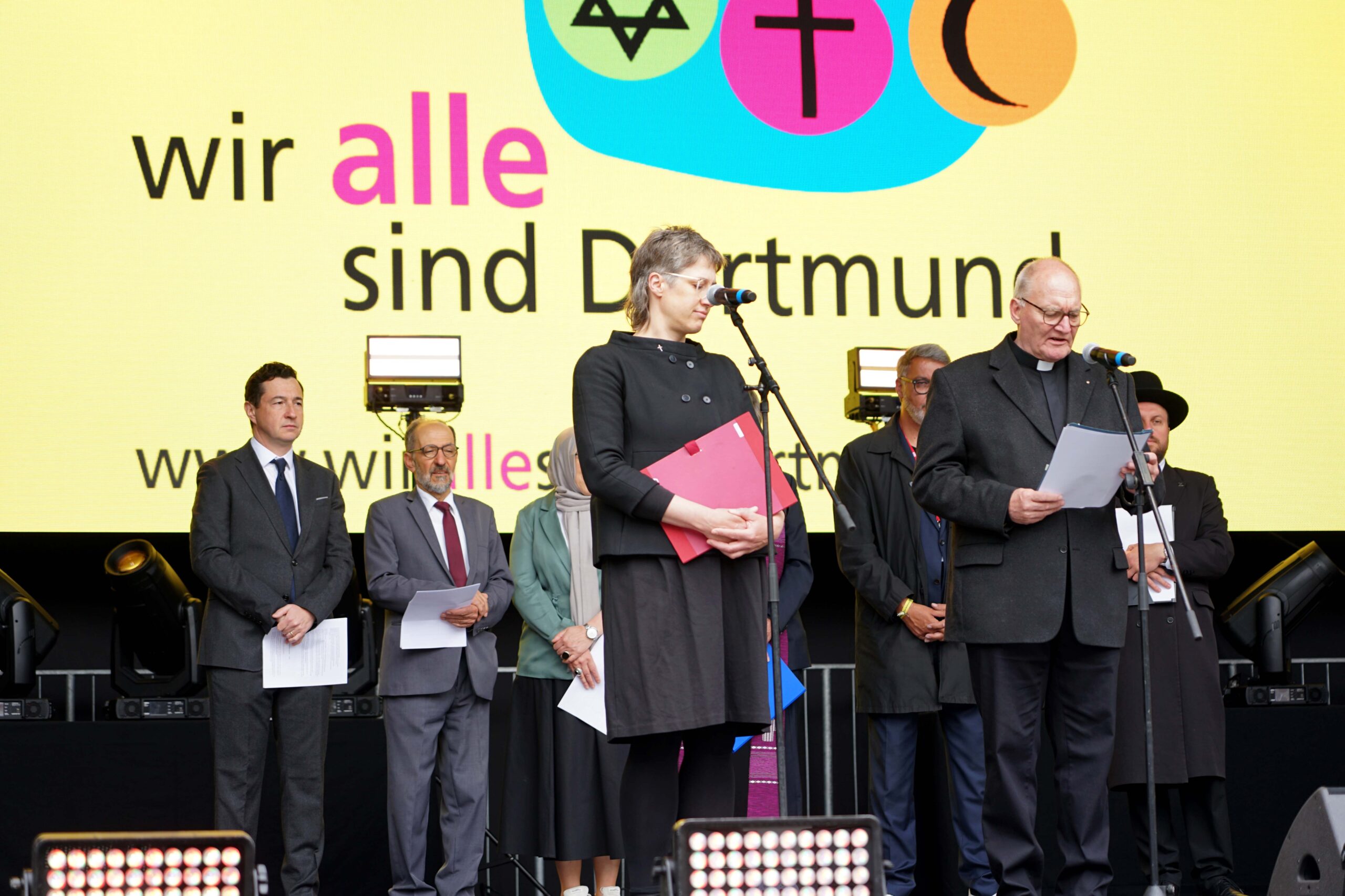 Vertreterinnen und Vertreter der verschiedenen Religionsgemeinschaften, sprachen in ihren Traditionen Gebete für Frieden und Zusammenhalt, darunter Propst Andreas Coersmeier (vorne rechts) für die Katholische Stadtkirche Dortmund. Foto: Michael Bodin / Kath. Pressestelle Dortmund