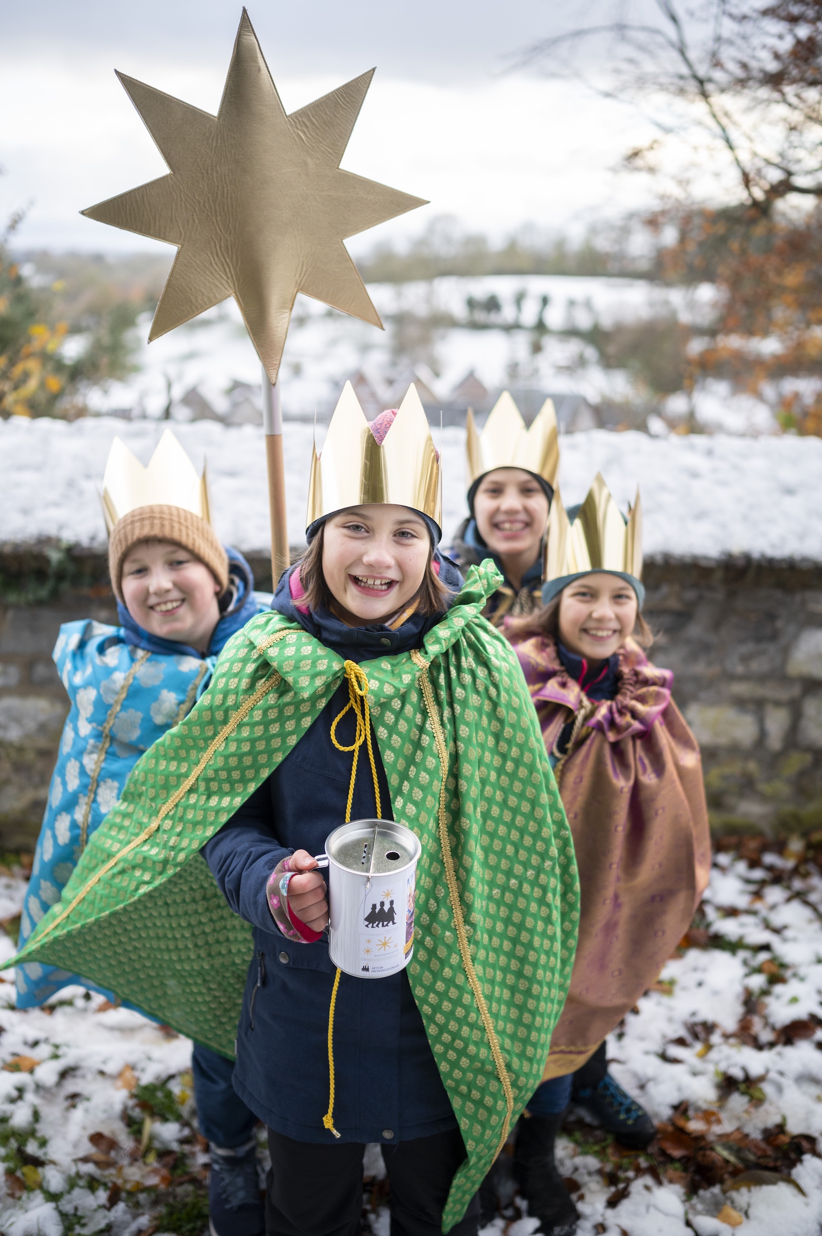 Sternsingergruppe mit Stern und Spendendose