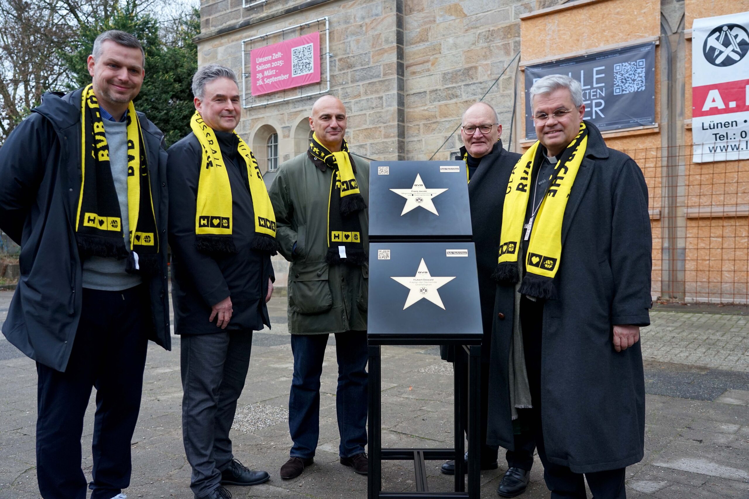 Zwei neue Steine für den BVB Walk of Fame – für Franz Jacobi und Kaplan Hubert Dewald – wurden am Freitag vor der BVB-Gründerkirche präsentiert (v.l.): BVB-Vizepräsident Daniel Lörcher, Bernd Möllmann (BVB e.V.), Oberbürgermeister Alexander Kalouti, Propst Andreas Coersmeier für die Katholische Stadtkirche Dortmund und Erzbischof Dr. Udo Markus Bentz. Foto: Michael Bodin / Erzbistum Paderborn