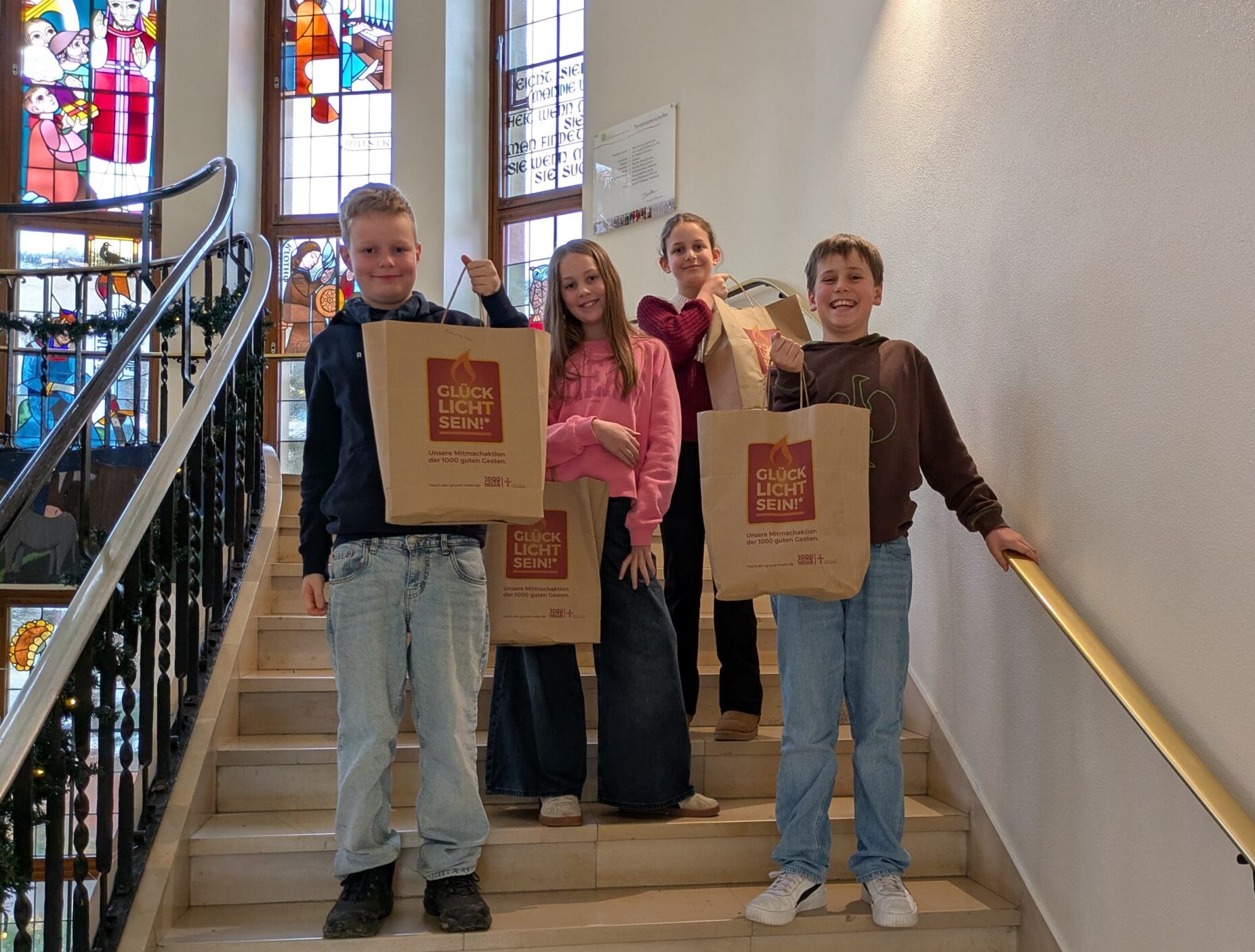 Stehen mit ihren Glücklich/t Tüten in der Treppe ihrer Schule, dem Liebfrauengymnasium in Büren.