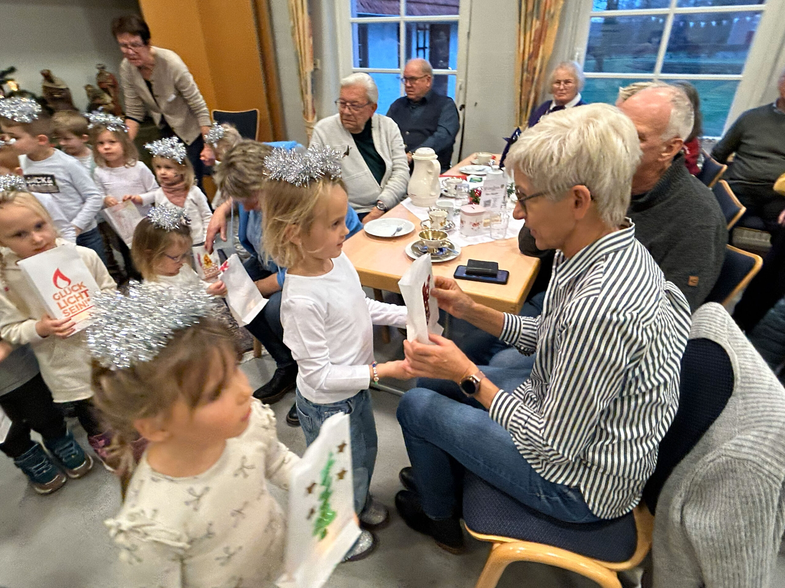 Mädchen aus dem Kindergarten übergibt ein Glücklicht and ihre Oma