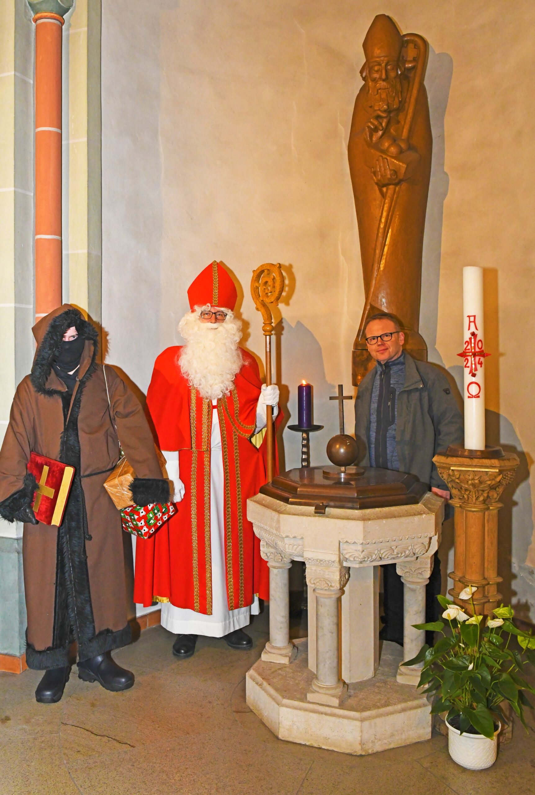 Nikolaus mit Knecht Ruprecht und Pfarrer Klaus Engel in der St.-Nikolaus-Kirche Olsberg.