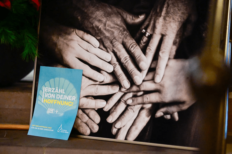 Blick auf viele unterschiedliche Hände und das Logo des Heiligen Jahres