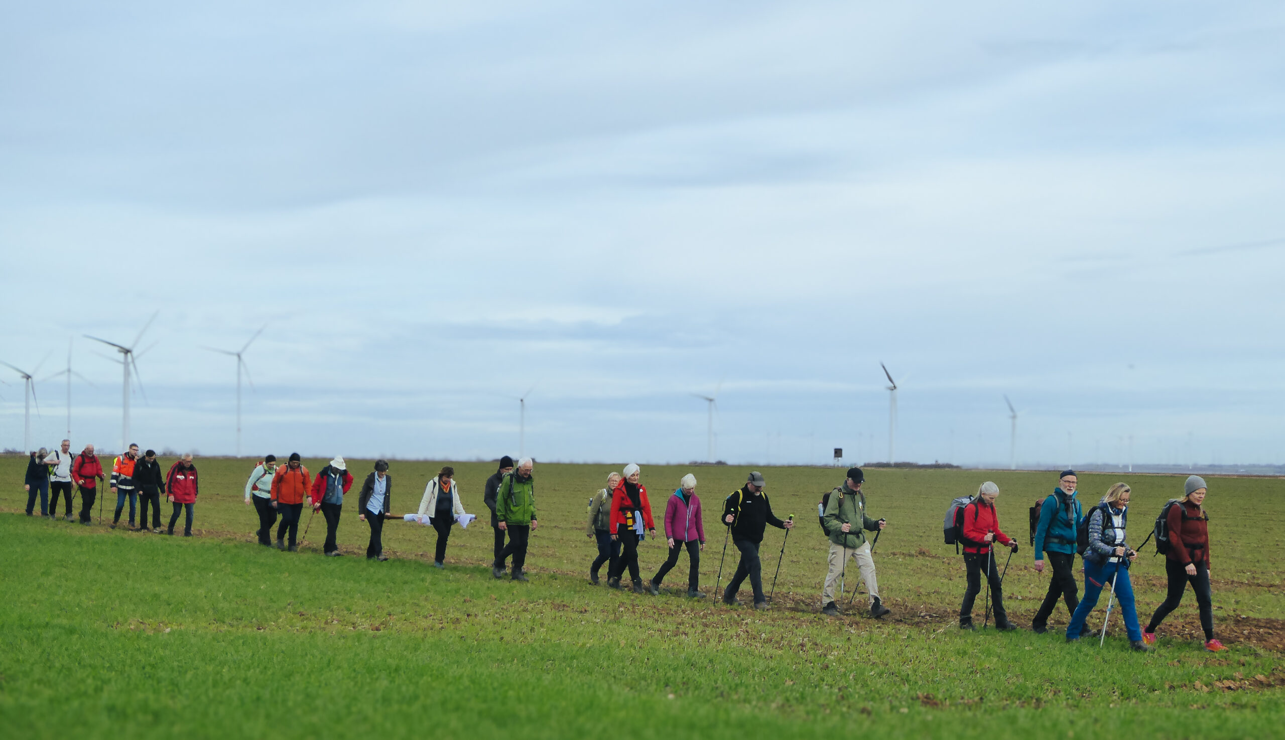 Wallfahrer pilgern durch die grüne Landschaft.