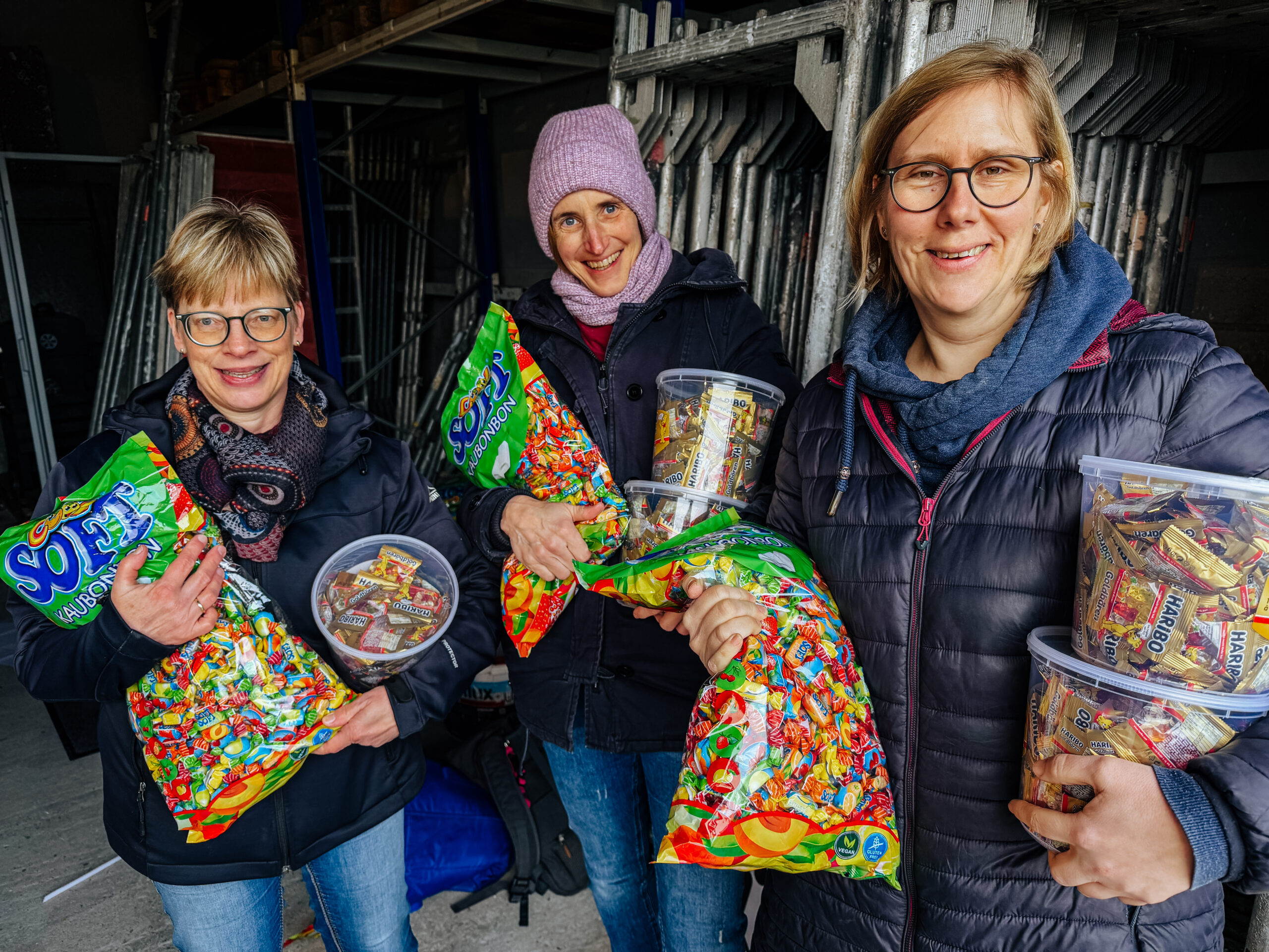 Ehrenamtliche halten Bonbontüten in den Händen.