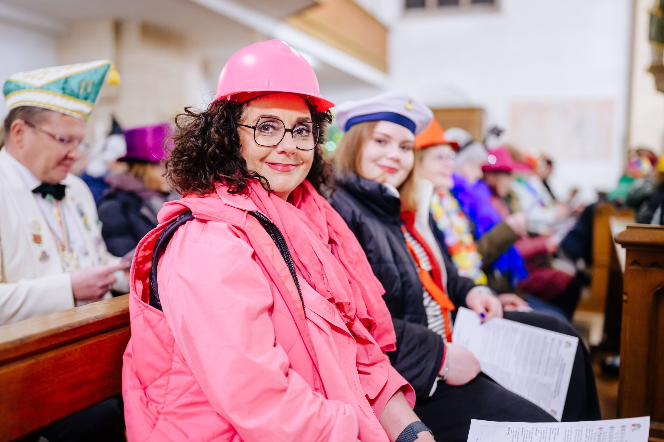 Frau sitzt verkleidet in Kirchenbank