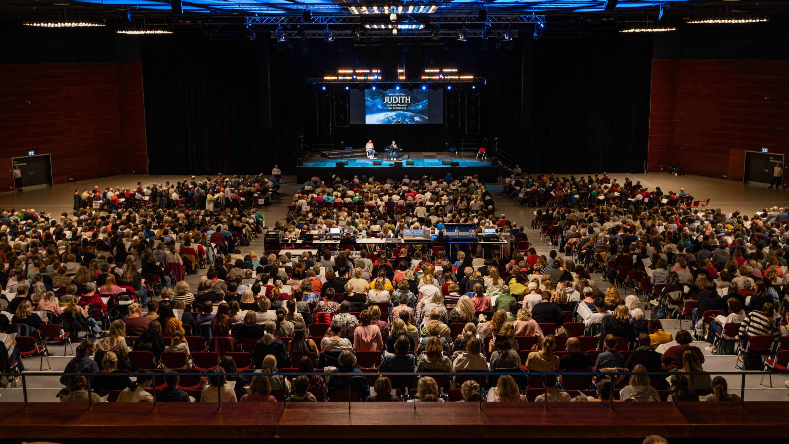 Sängerinnen und Sänger kommen für das Musical „Judith und das Wunder der Schöpfung“ zu einem großen Chorprojekt zusammen und singen gemeinsam.