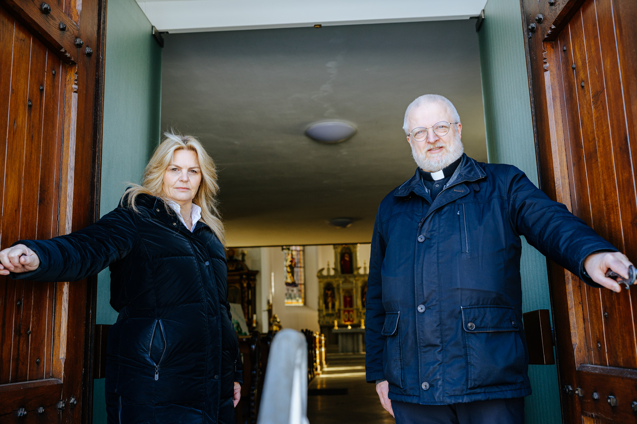 Nina-Maria Mehring und Pastor Stefan Stratmann öffnen die Kirchentür zu St. Cyriakus in Kleinenberg