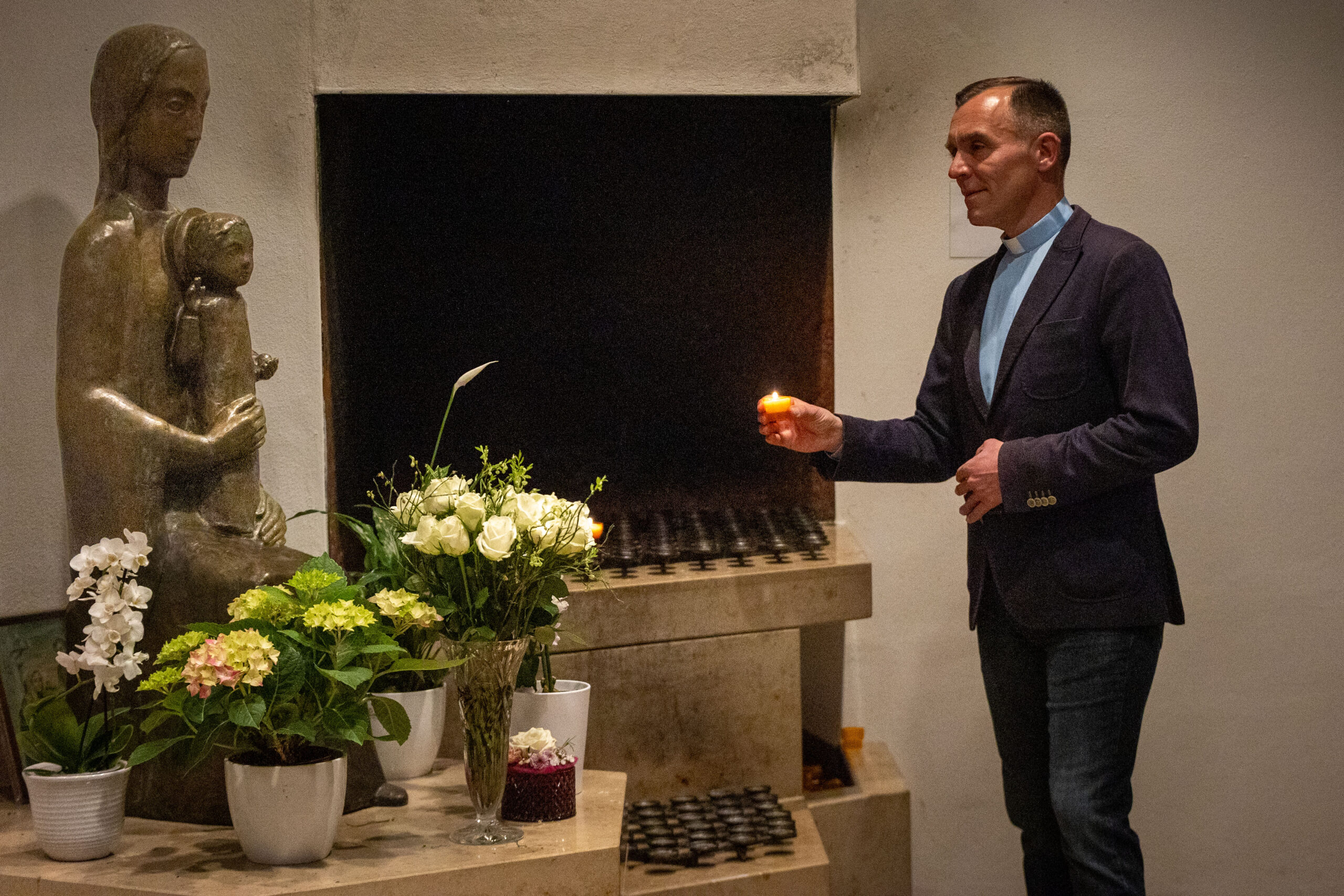 Bild von Pastor Laubhold wie er eine Kerze anzündet