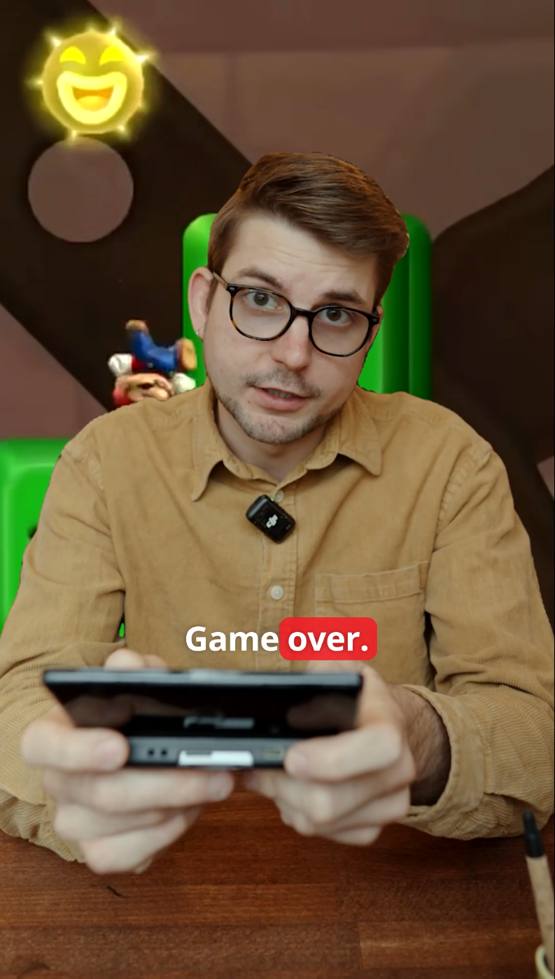 Ein junger Nann hält eine Spielkonsole in den Händen, im Bild steht "Game Over" geschrieben.