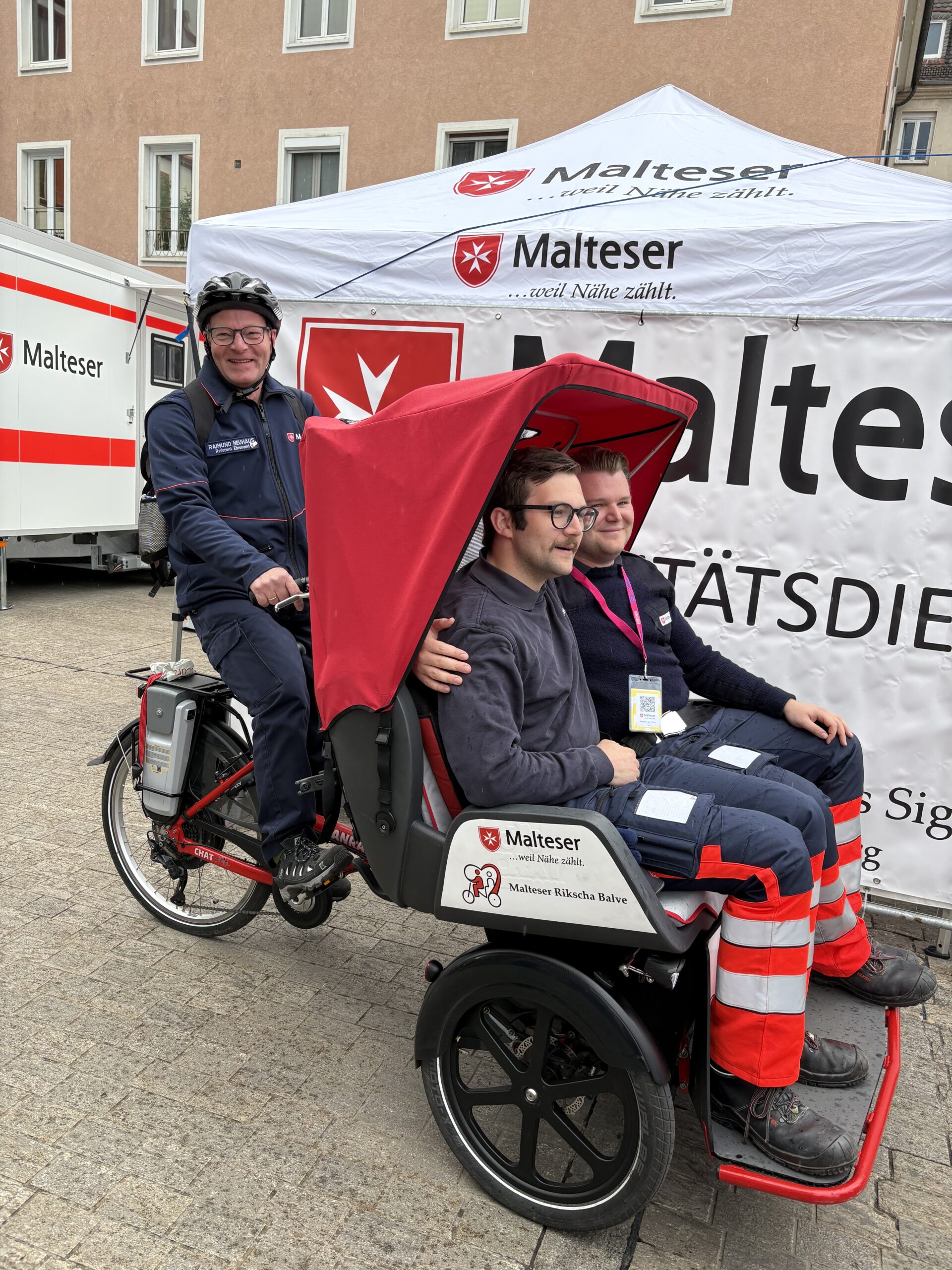 Der Rikscha-Dienst: Raimund Neuhaus aus der Malteser Gliederung Balve tritt kräftig in die Pedale – Malteser Kollegen aus Höxter machen eine Probefahrt.