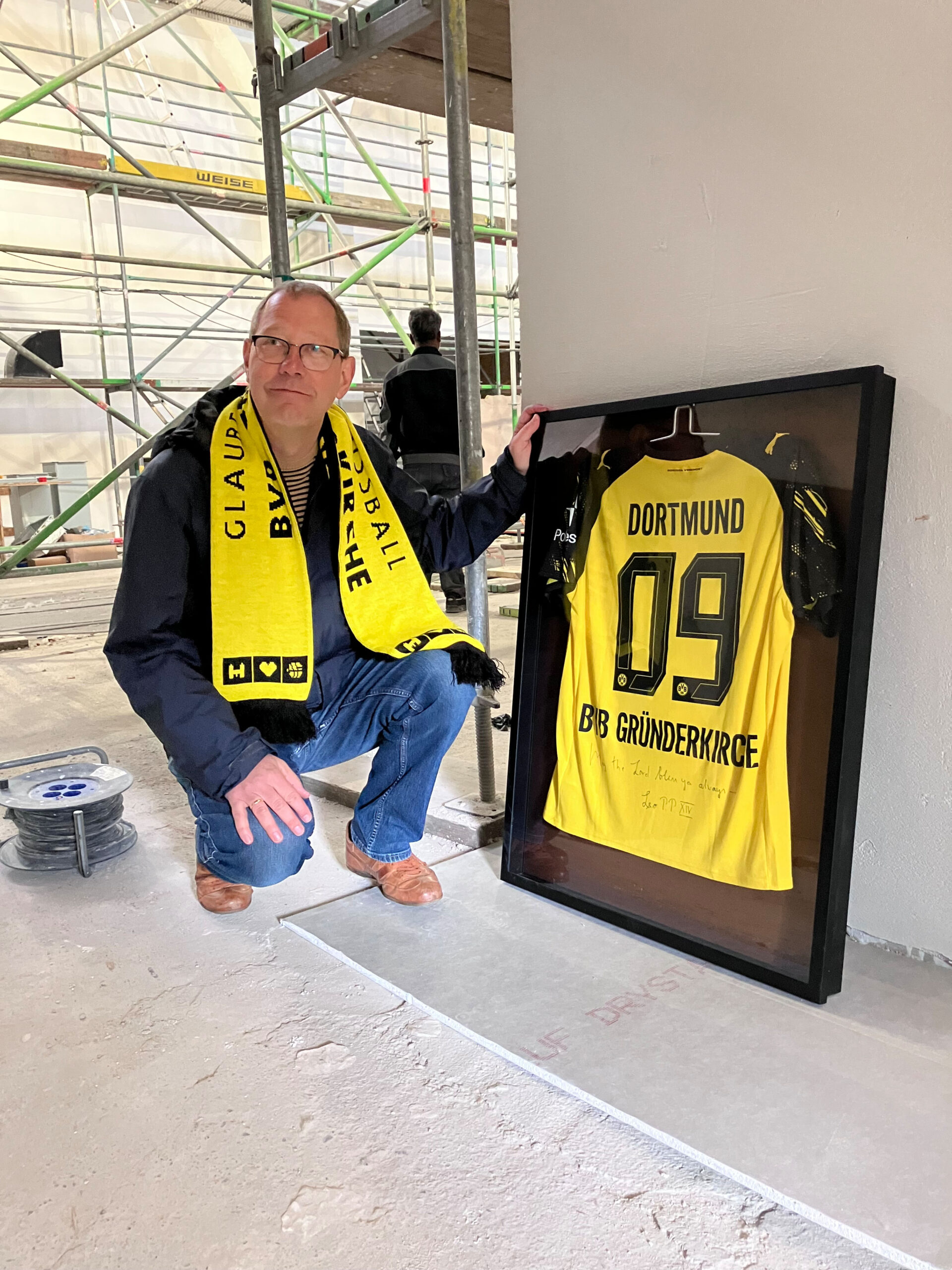 Karsten Haug von der BVB-Gründerkirche mit einem von Papst Leo XIV. gesegneten und signierten BVB-Trikot. Das Team der BVB-Gründerkirche war damit auch auf dem 104. Katholikentag in Würzburg präsent. Foto: privat / BVB-Gründerkirche