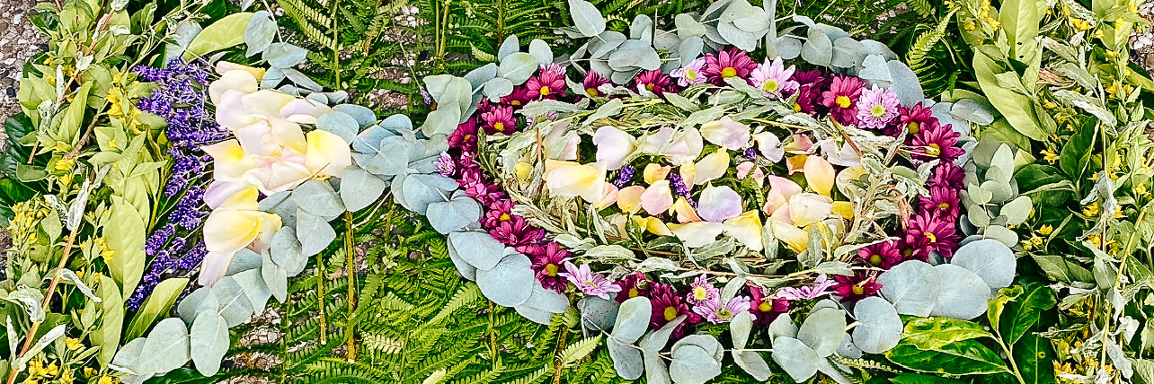 Kommunionkinder haben für die Fronleichnamsprozession ein Blumenbild gelegt, das einen Fisch zeigt.