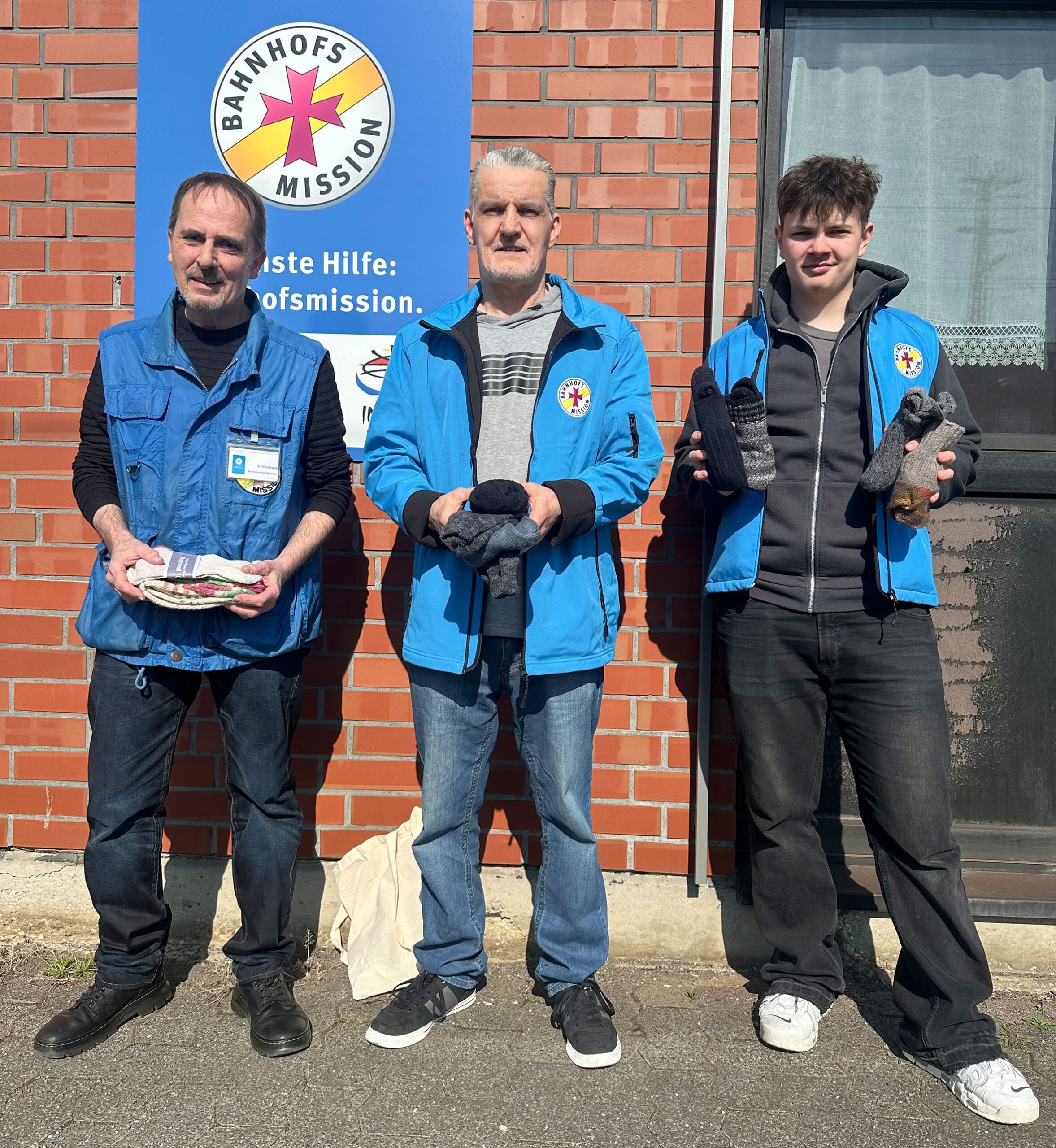 Bahnhofsmission: Mitarbeiter der Bahnhofsmission Paderborn übernahmen gespendete Wollsocken, um sie an Bedürftige weiter zu geben. Von links: Volker Hillebrand, Hans Ullrich und Andre Sokha.