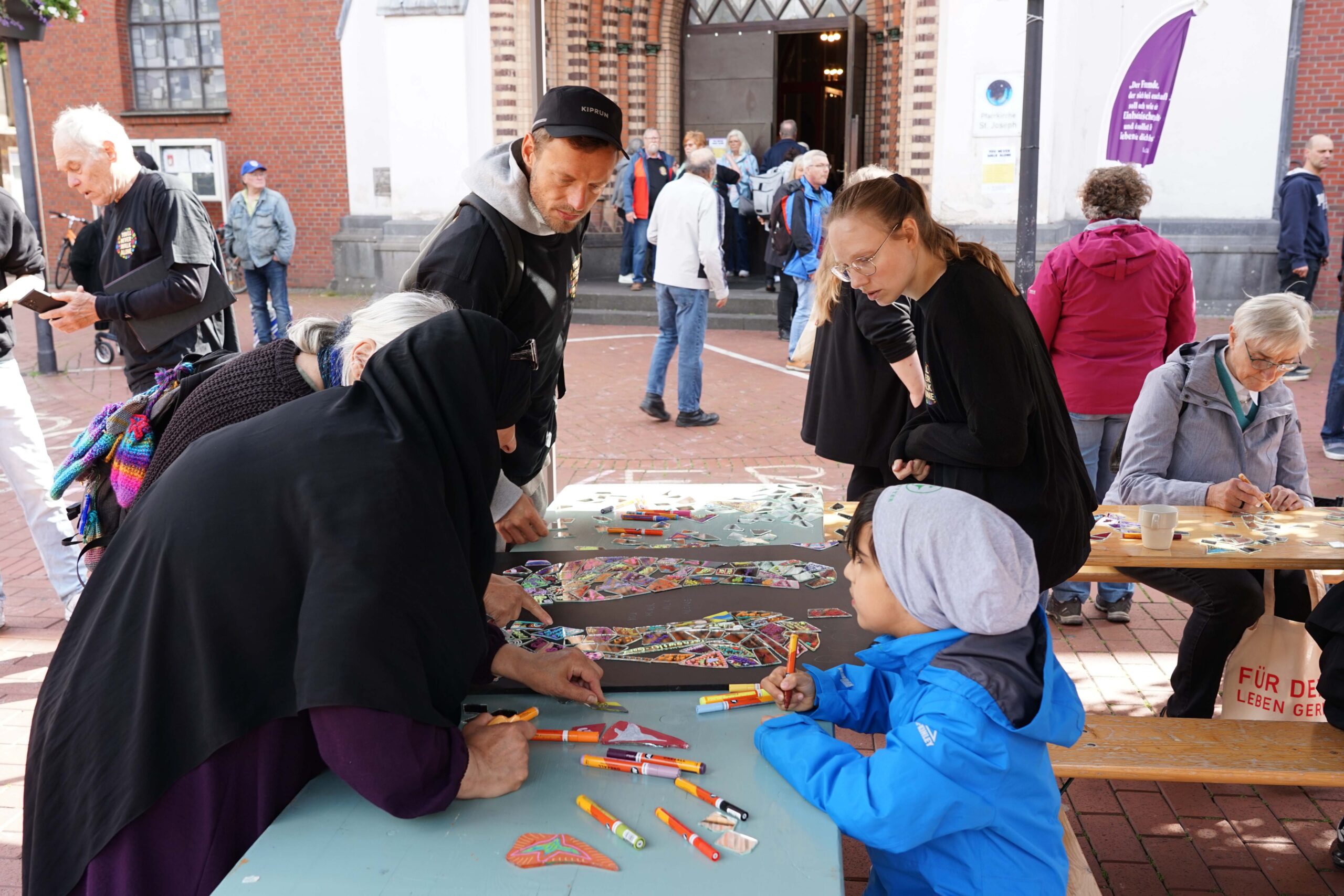 Der Künstler Hendryk von Busse (links) leitete die Kunstaktion zur Gestaltung von Spiegelscherben zu einem Bild. Foto: Michael Bodin / Erzbistum Paderborn