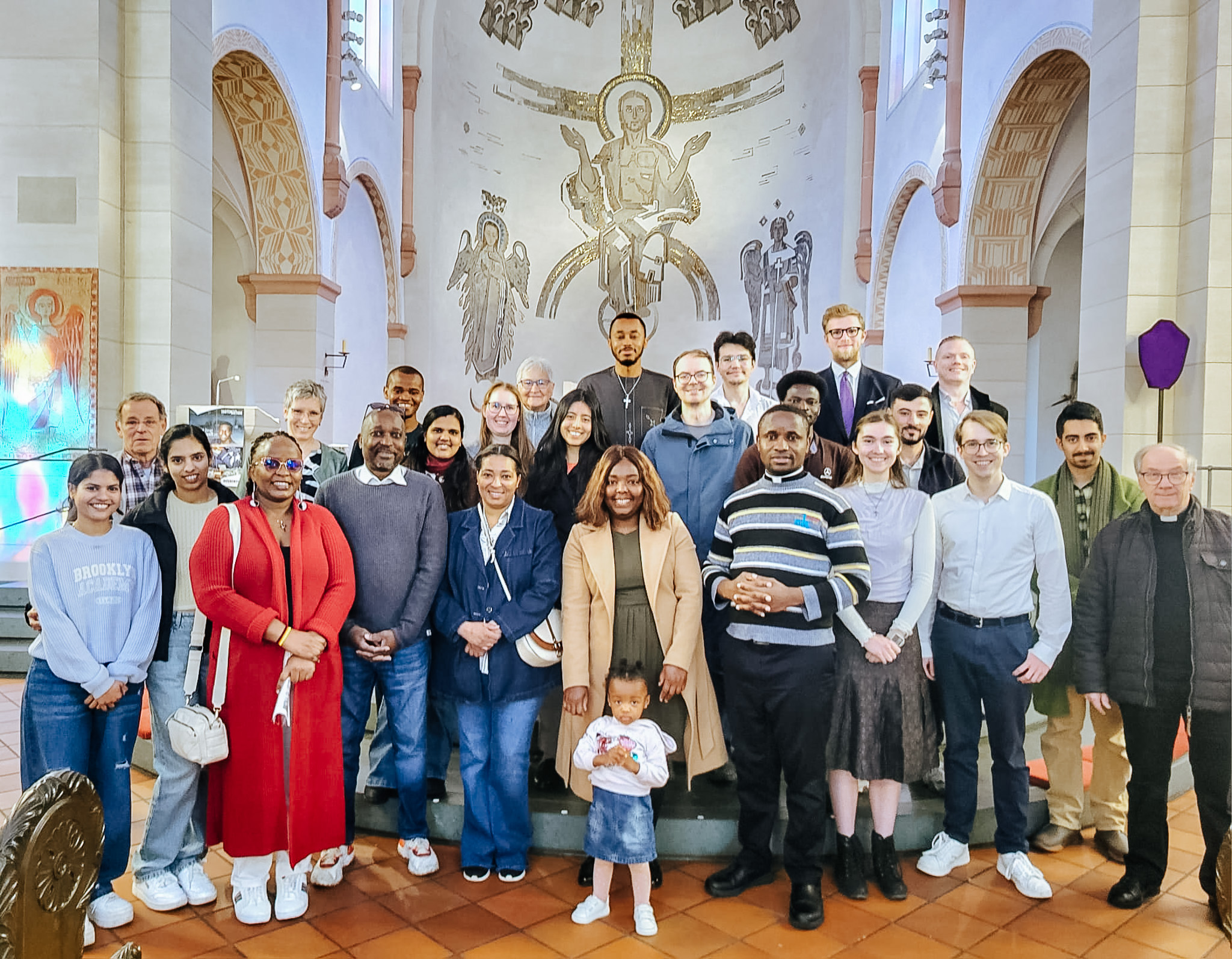 Mitglieder von Come and see stehen gemeinsam für ein Gruppenfoto in einer Kirche.