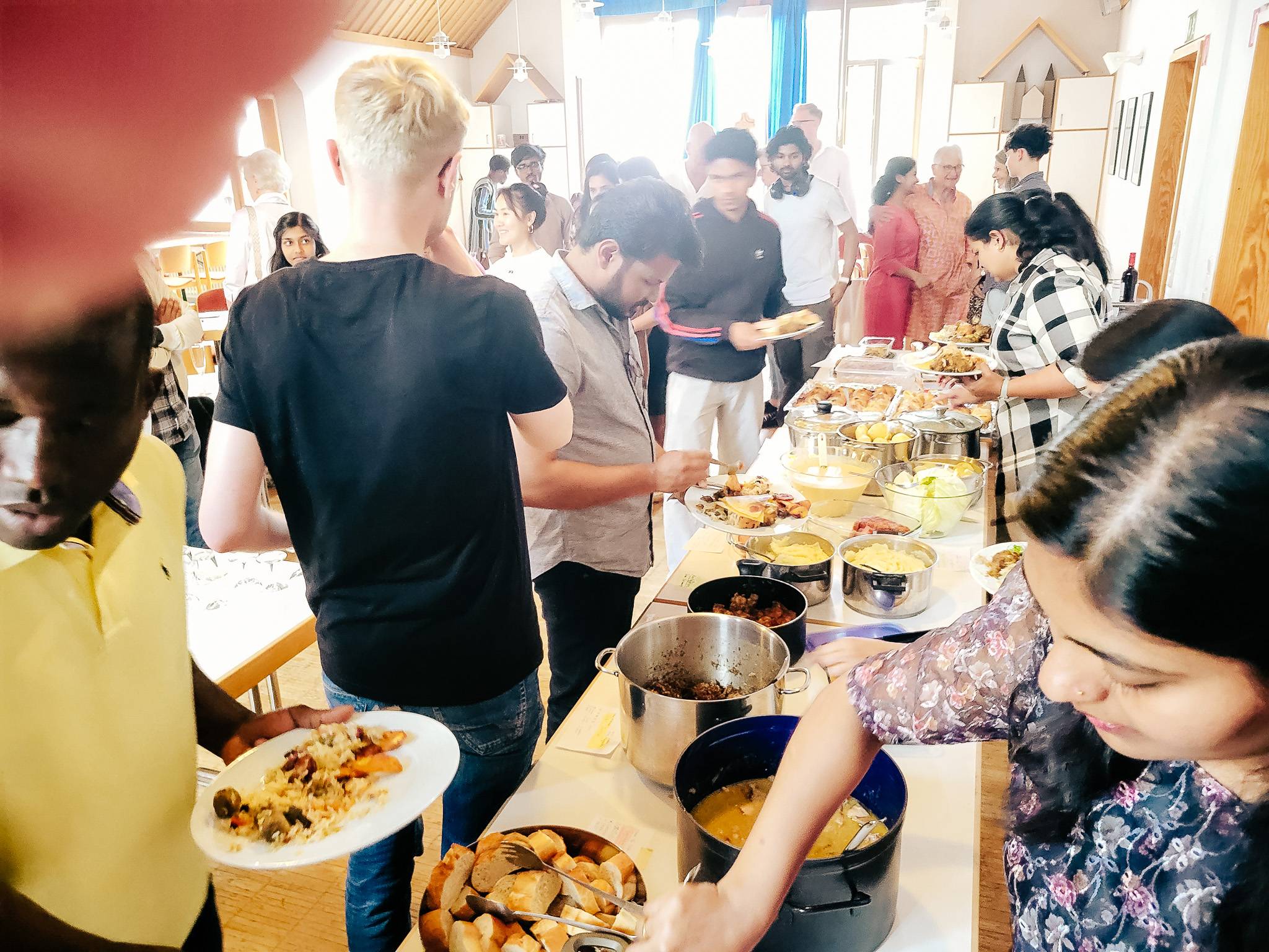 Buffet mit Speisen aus verschiedenen Ländern bei einer Begegnung von Come and see.