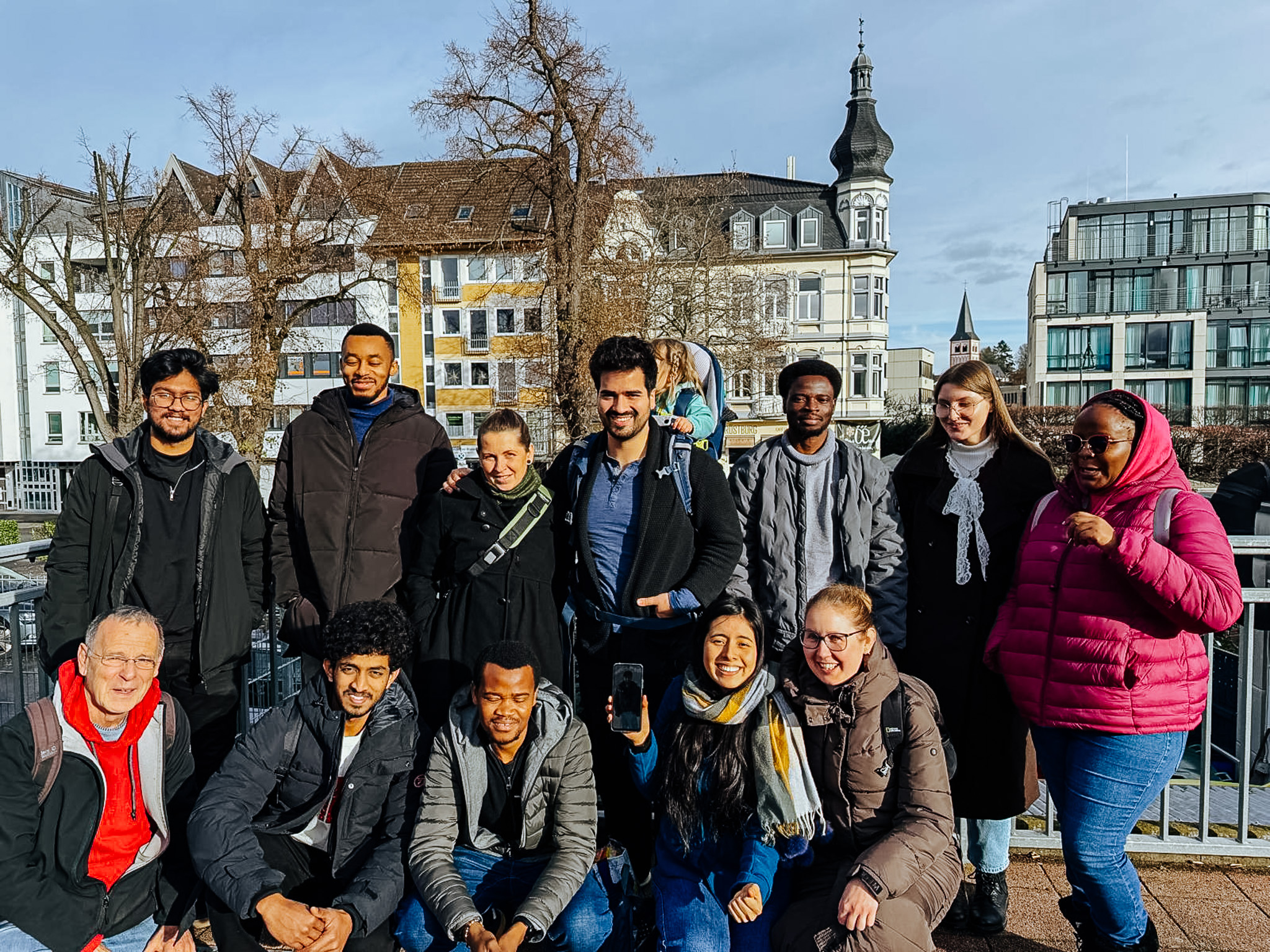 Mitglieder von Come and see stehen gemeinsam draußen für ein Gruppenfoto.