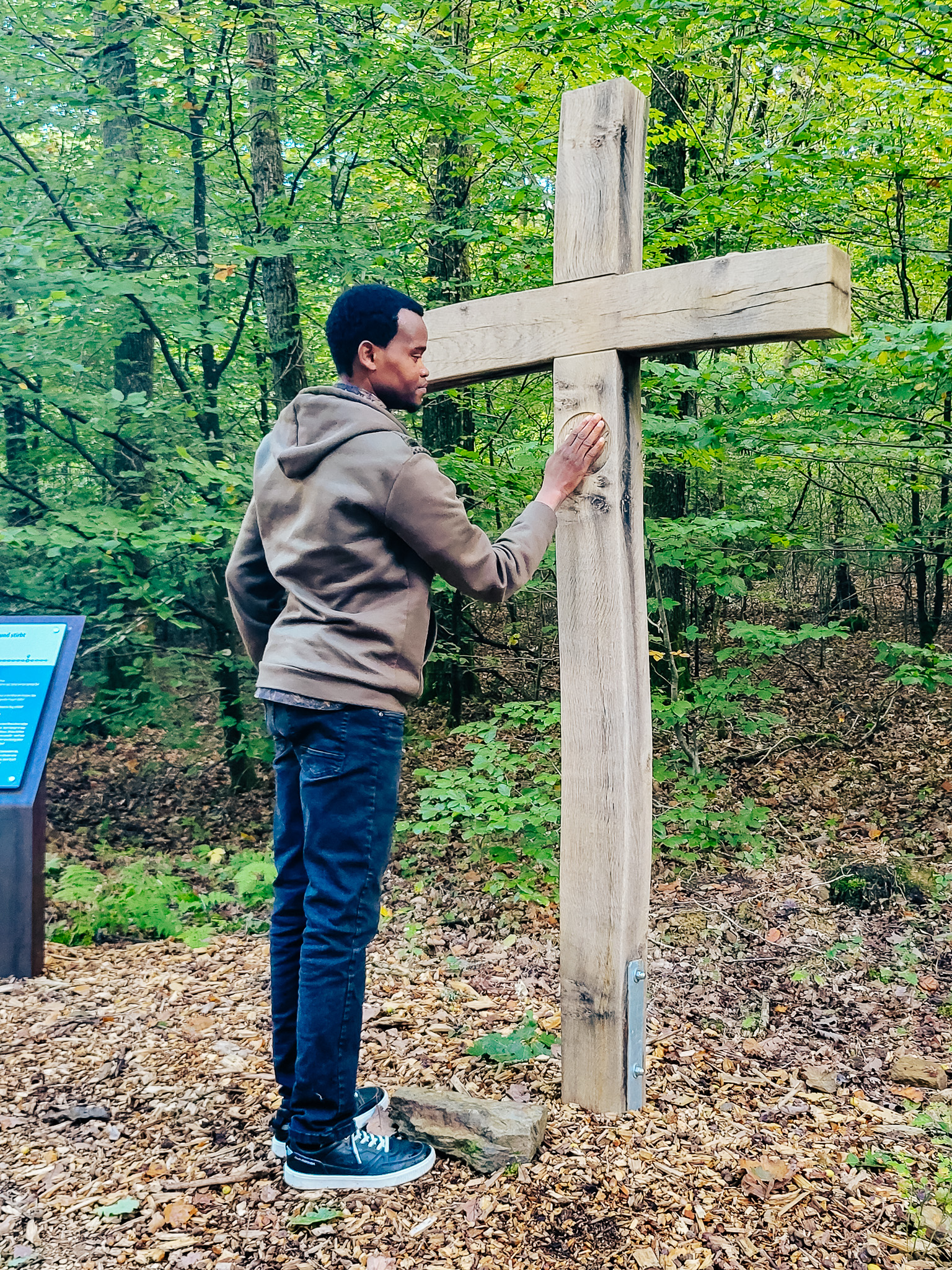 Ein Mitglied von Come and see berührt ein Kreuz.