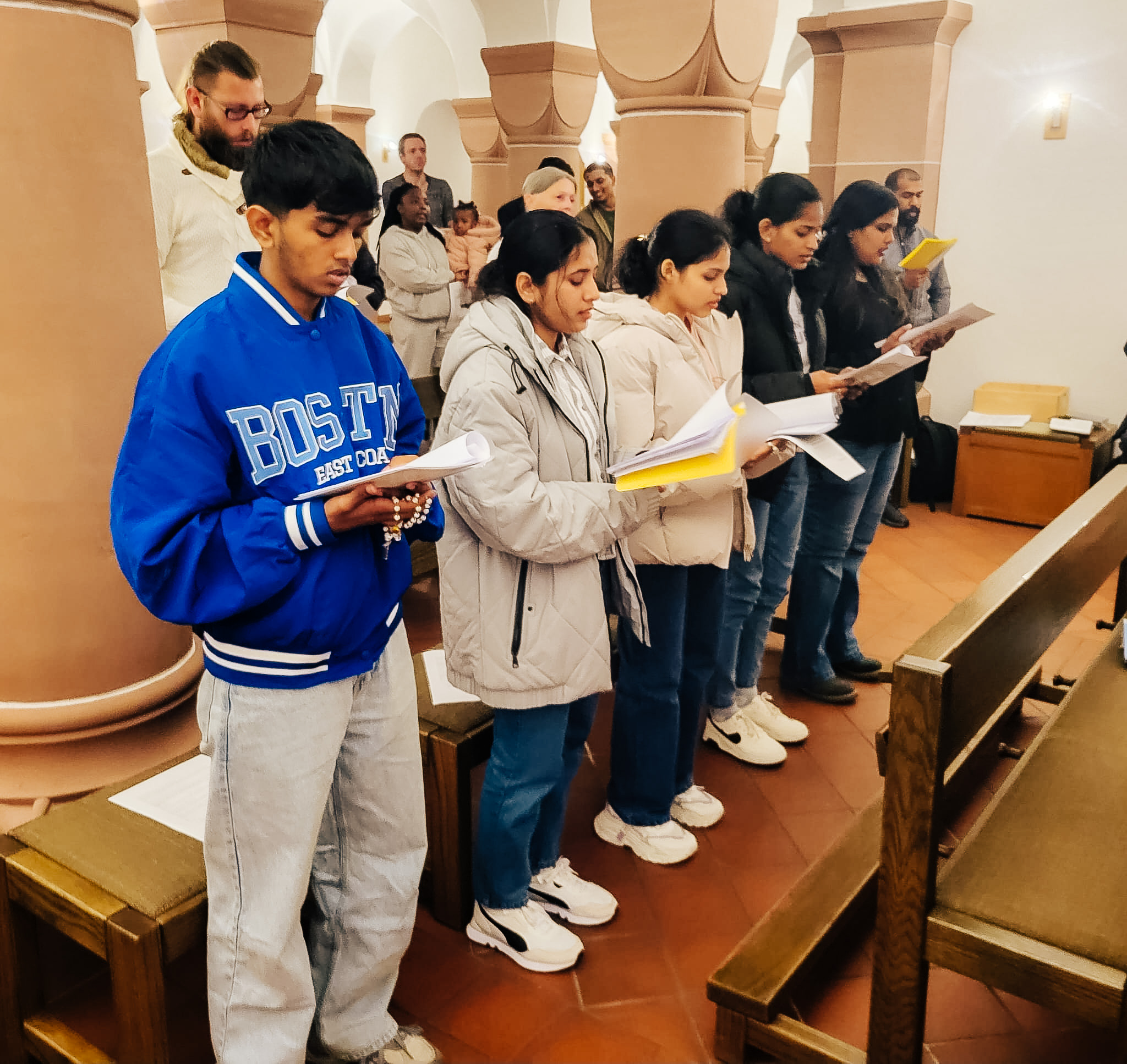 Mitglieder von Come and see singen gemeinsam in einer Kirche.
