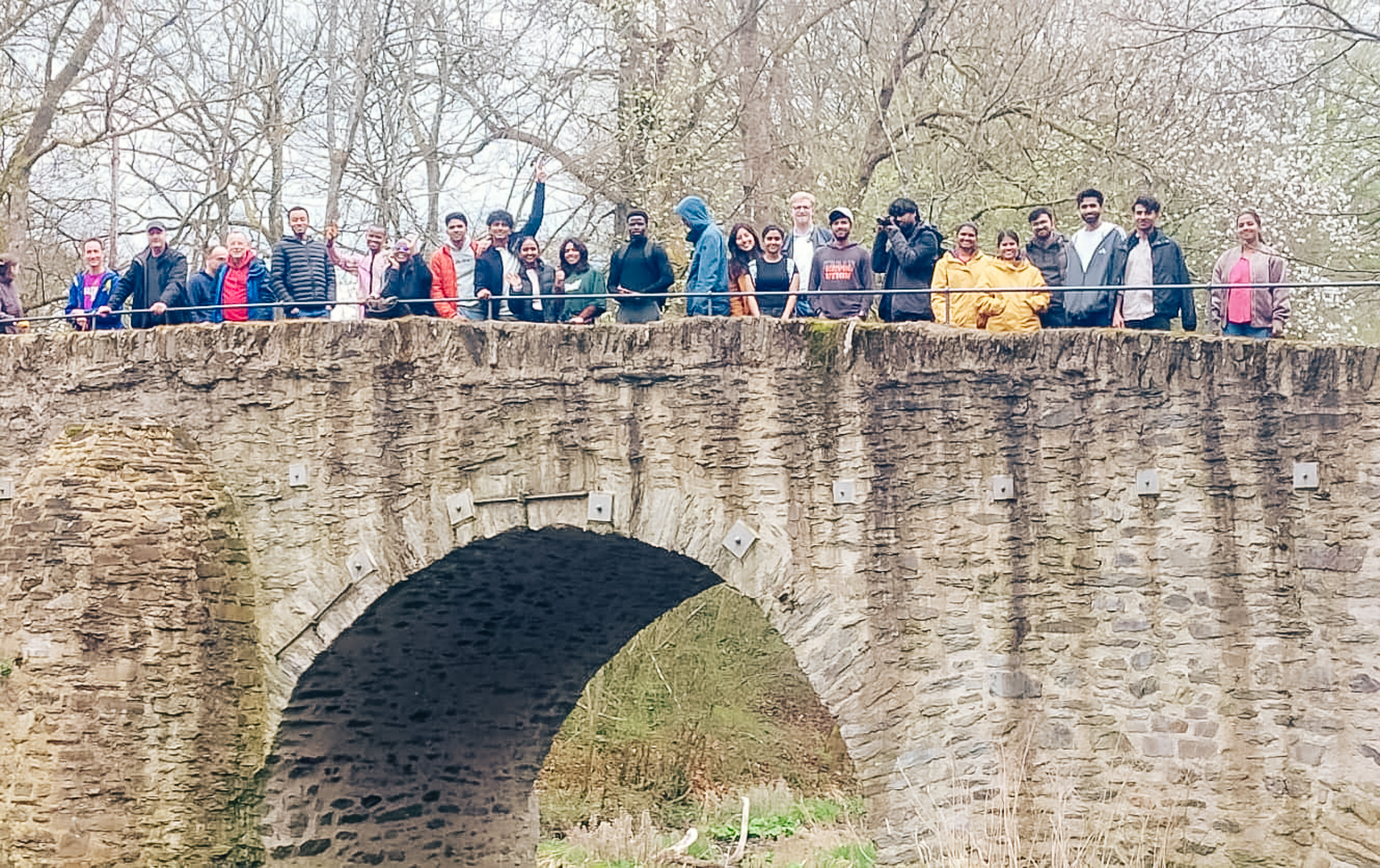 Mitglieder von Come and see stehen gemeinsam auf einer Brücke.